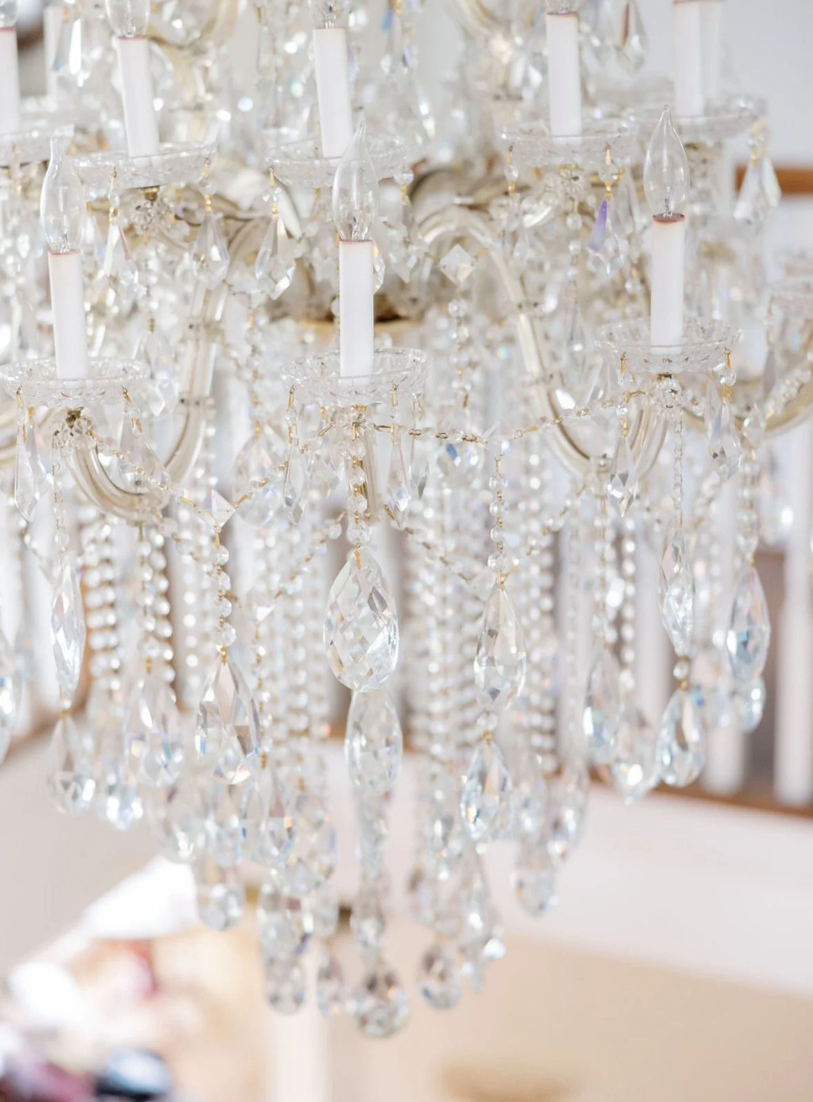 Close-up of a crystal chandelier with hanging beads and candle-style lights.