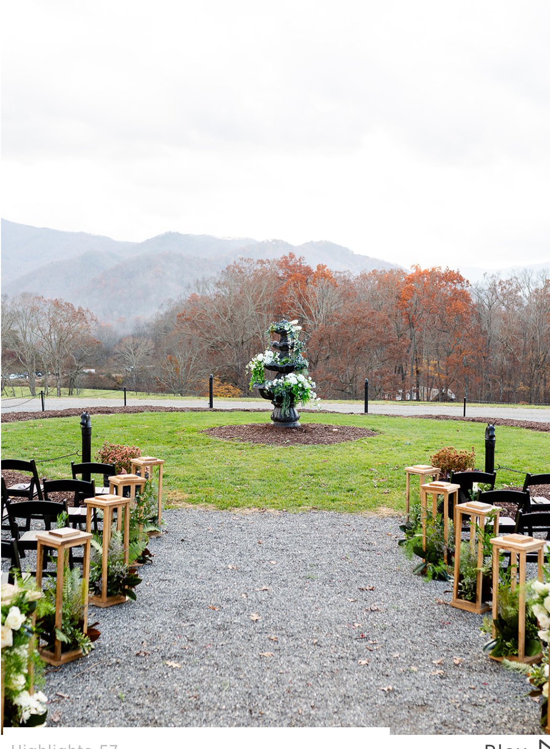Outdoor wedding ceremony setup with chairs, floral decorations, and a fountain in a scenic mountain landscape.