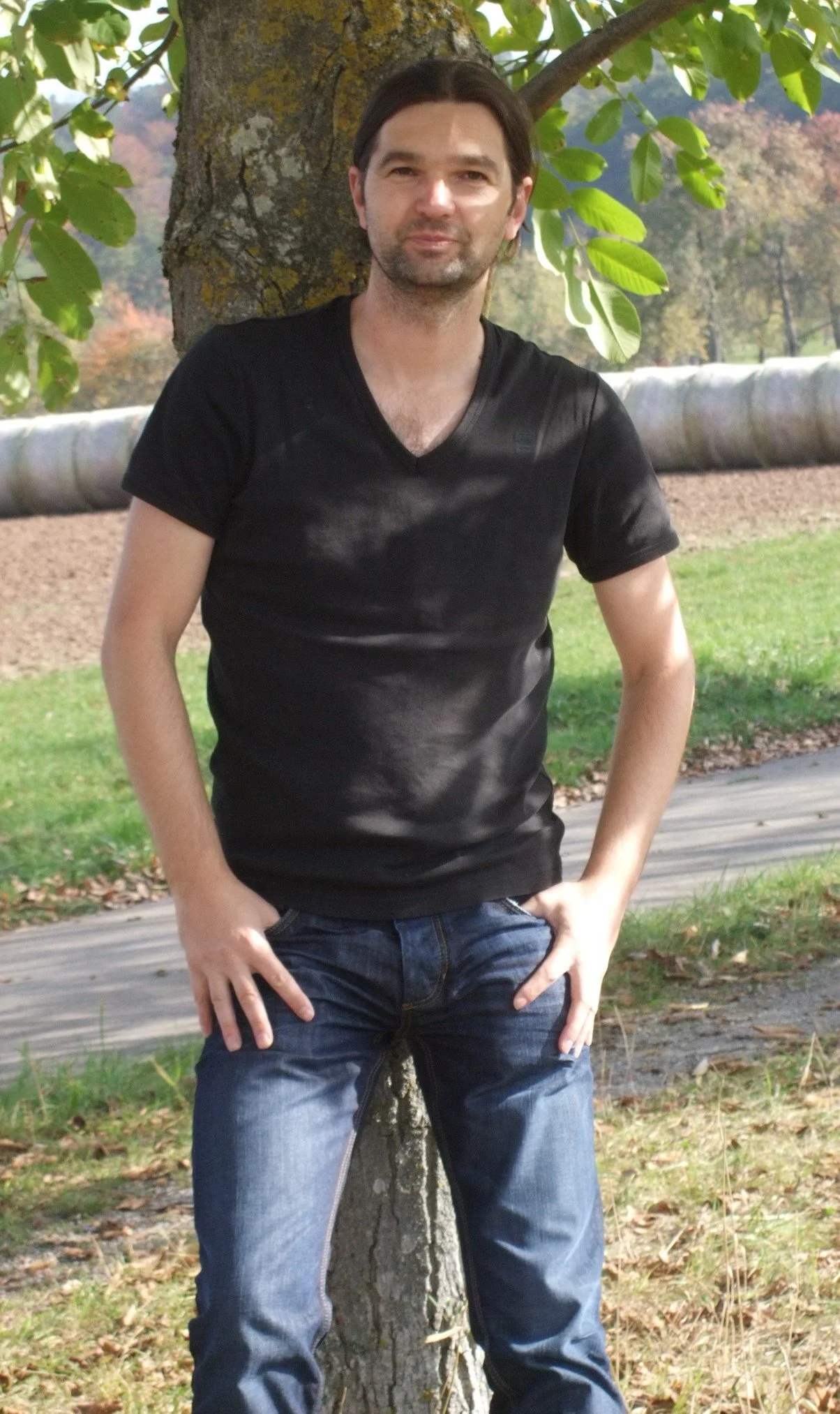 Hier bin ich Zoran Salatovic in der Natur zu sehen. An einem Baum angelehnt an einem sonnigem Tag.