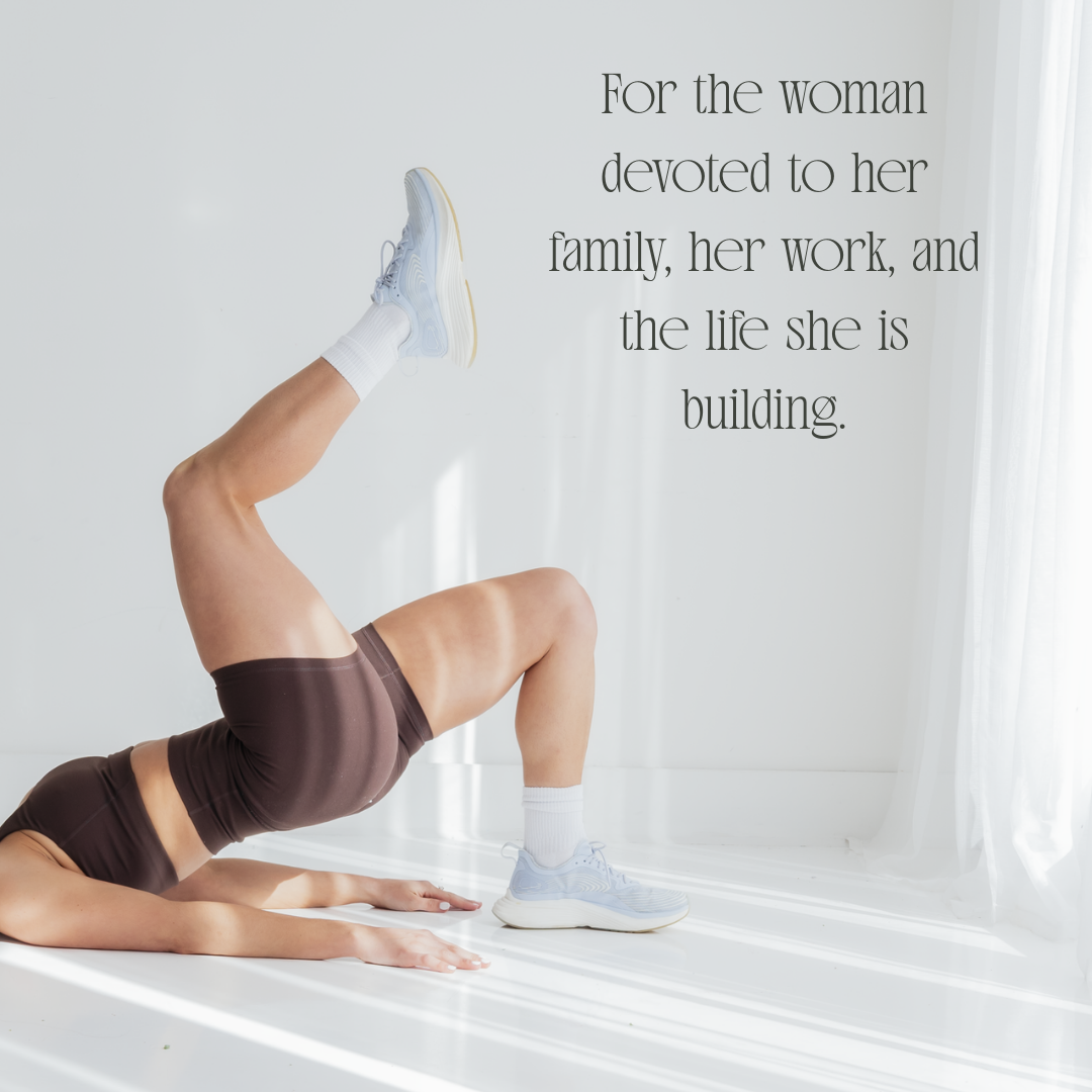 A woman doing a leg raise exercise on the floor in a bright room with sunlight and curtains, with a quote about dedication to family and work.