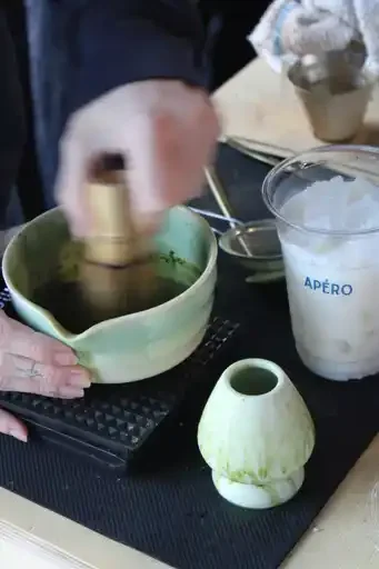 Professional barista hand-whisking premium Japanese matcha in a green ceramic bowl. Authentic matcha preparation for a luxury coffee catering service and brand activation event in Ottawa, Ontario.