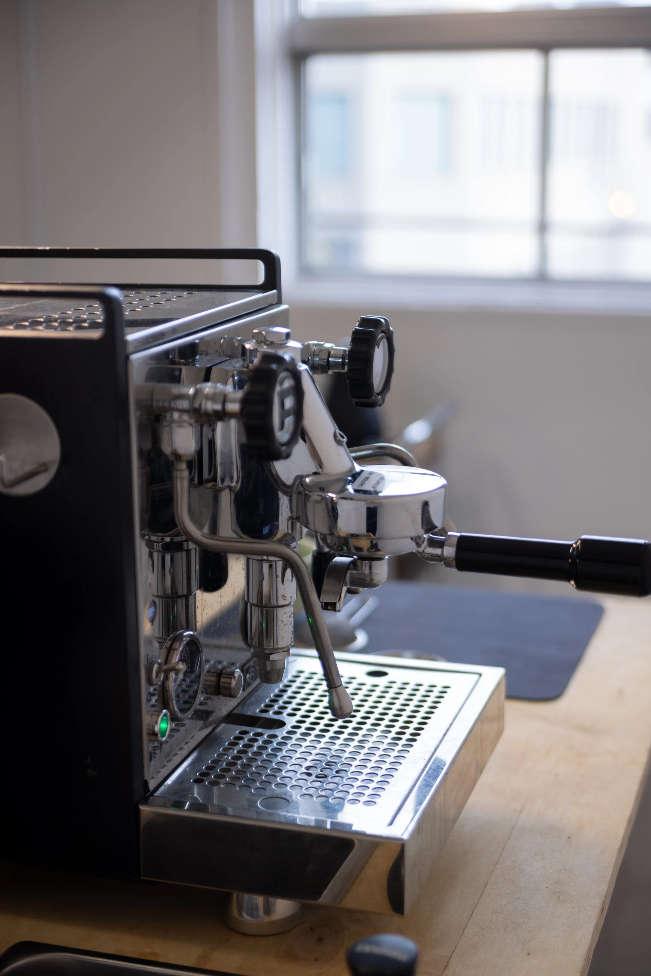 Close-up of a shiny, professional-grade espresso machine on a wooden countertop, providing espresso and coffee catering for events in the Ottawa-Gatineau area.