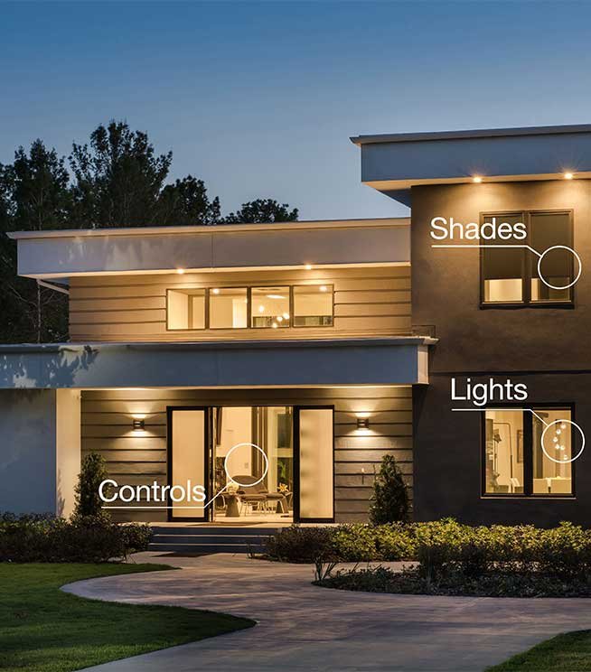 Modern house exterior at dusk with labeled features: shades, lights, controls, and landscaped front yard.