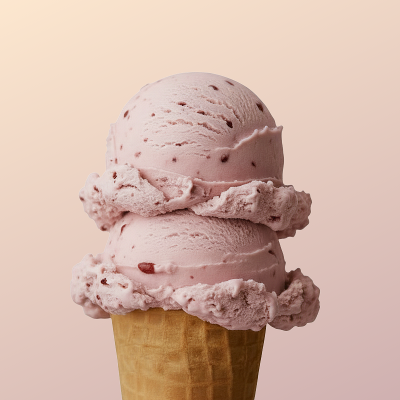 Two scoops of pink strawberry ice cream in a waffle cone
