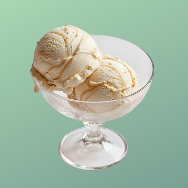 Two scoops of vanilla ice cream in a glass dessert dish against a light green background.