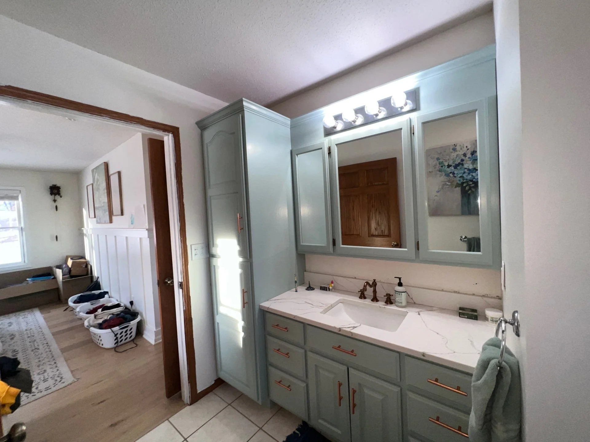 Large bathroom vanity painted in light pale blue with bronze hardware in Barron County Wisconsin