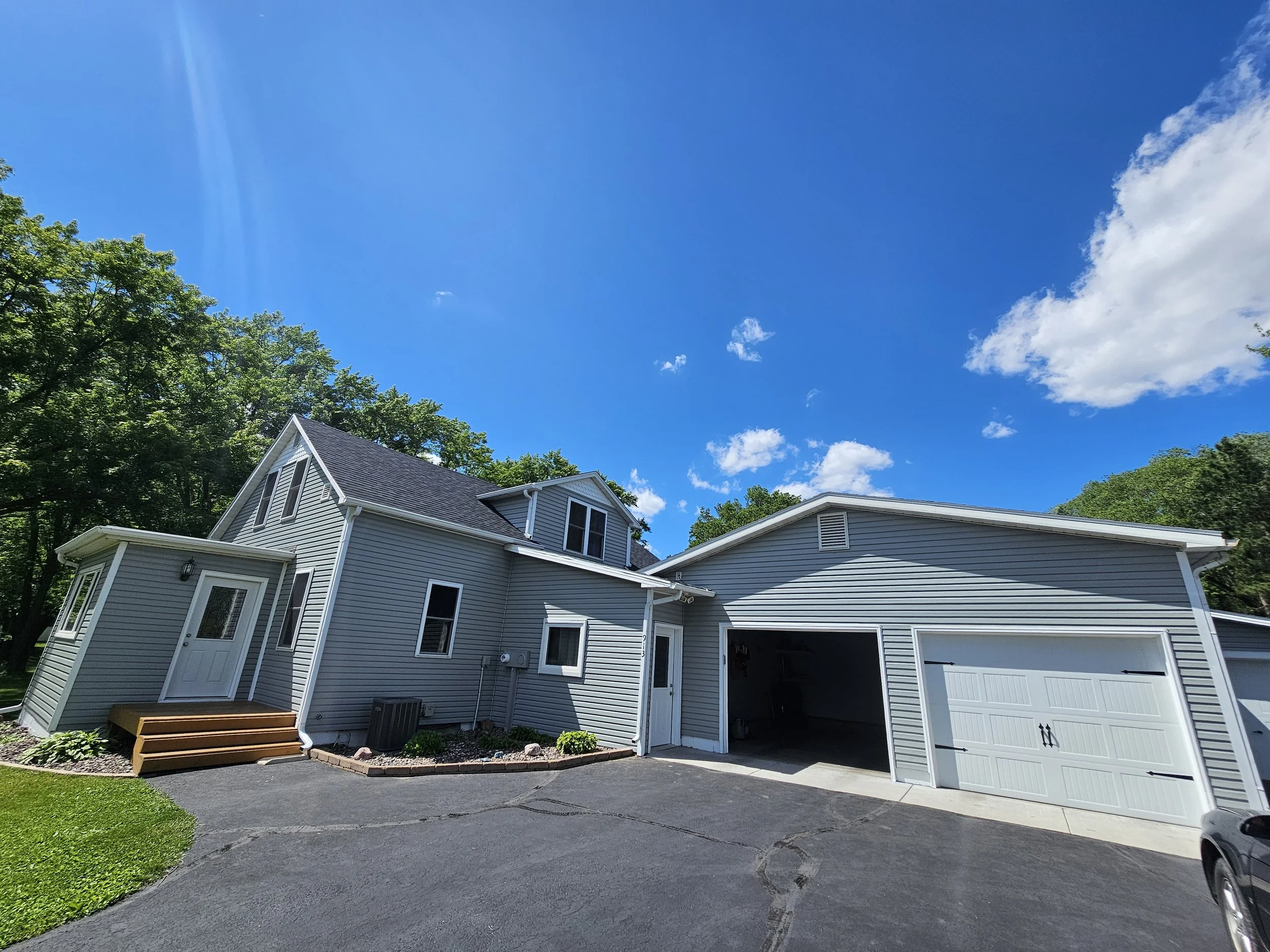Exterior painting using gray and white paints in Colfax Wisconsin to provide new finishes to siding and trim