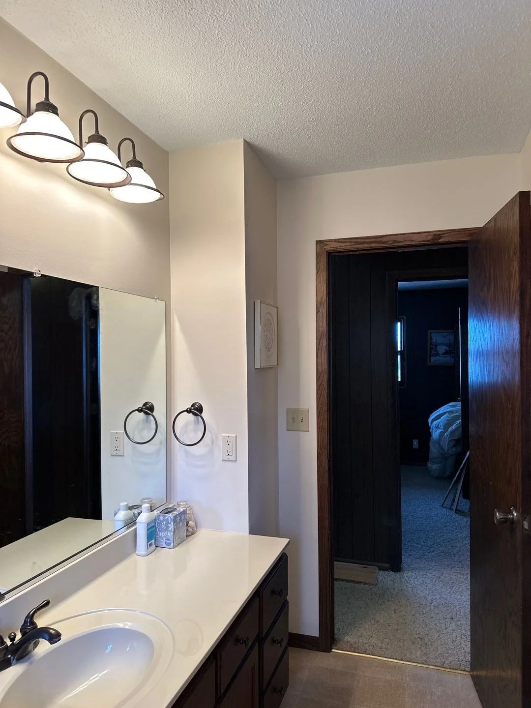 Light walls dark cabinets and dark wood create an elegant bathroom