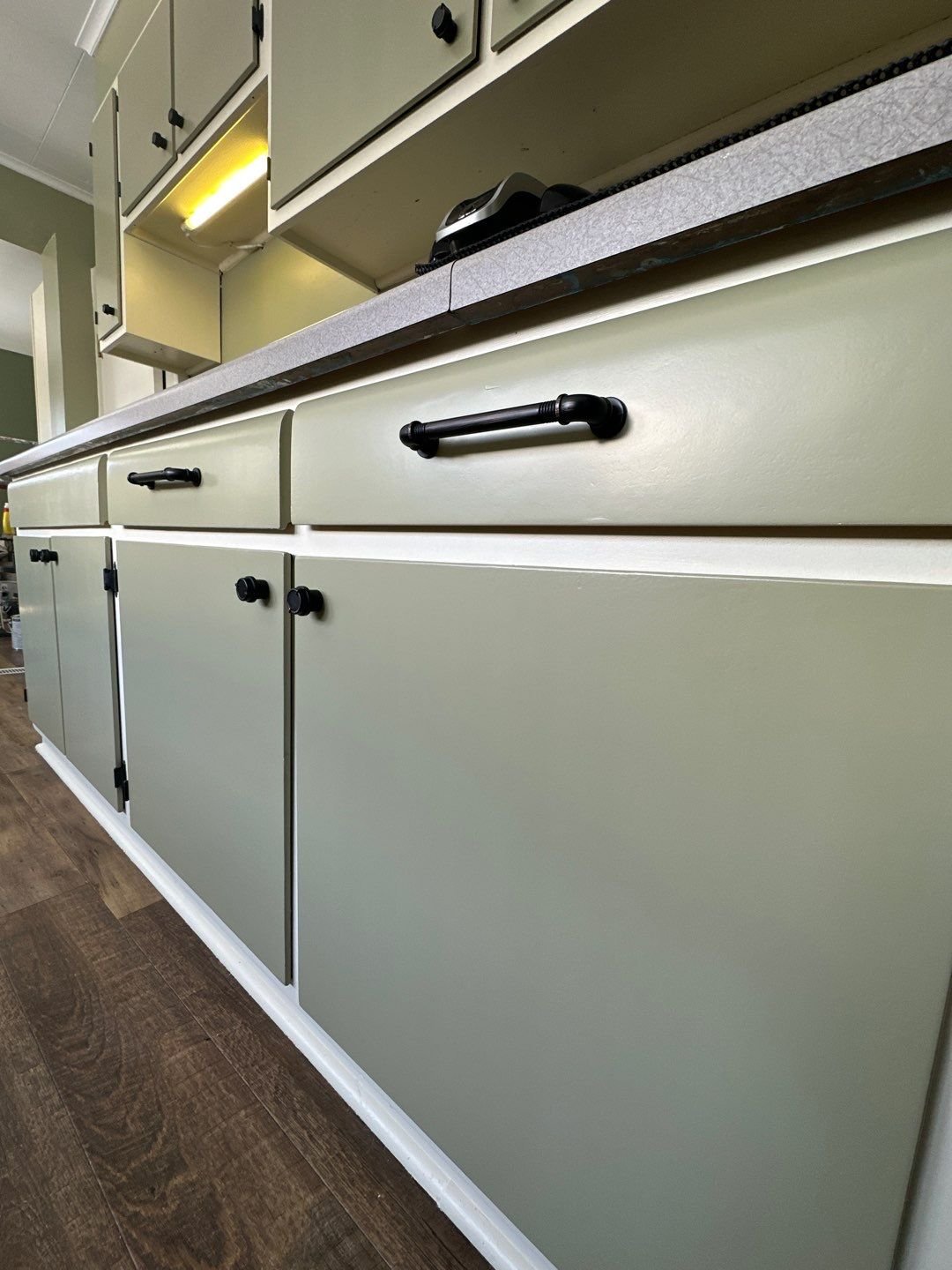 Green and white kitchen cabinet painted in Eau Claire Wisconsin