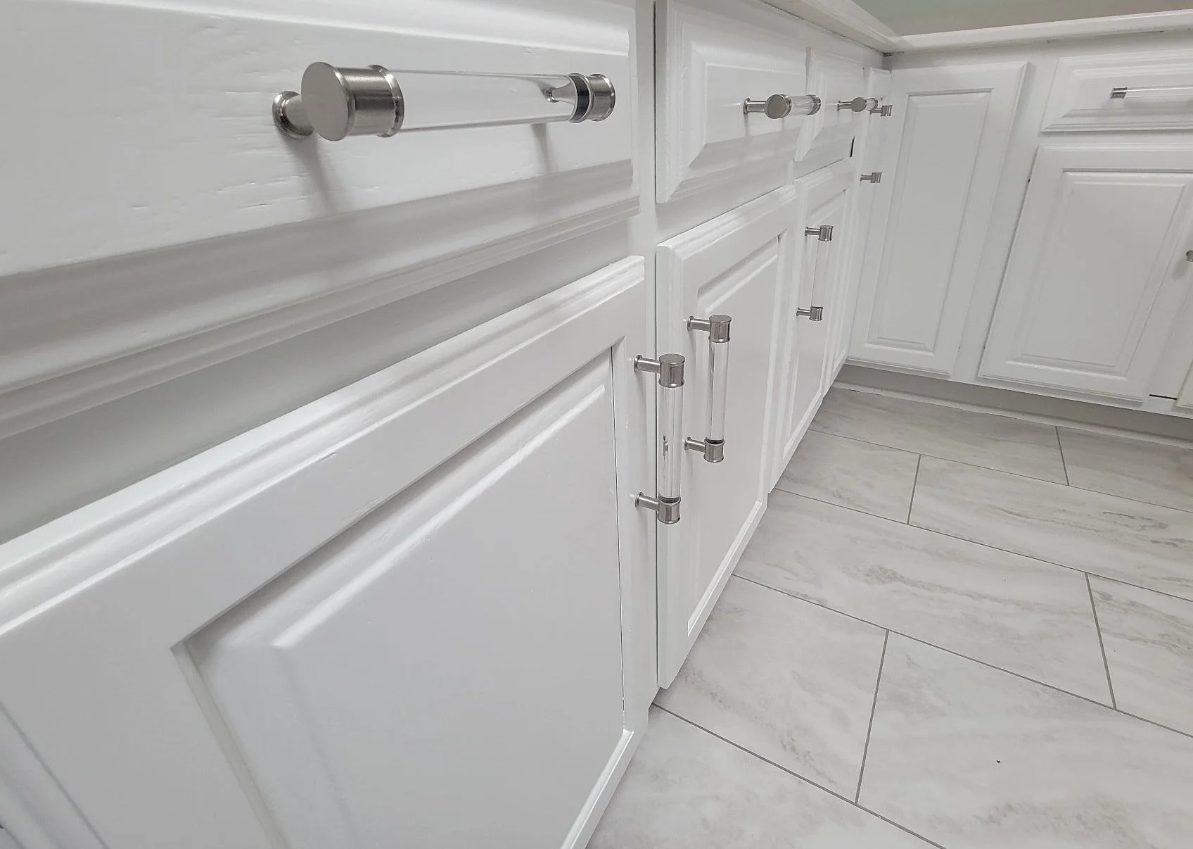 White painted cabinets with crystal handles painted by Barefoot Painter LLC in Phillips Wisconsin in Price County