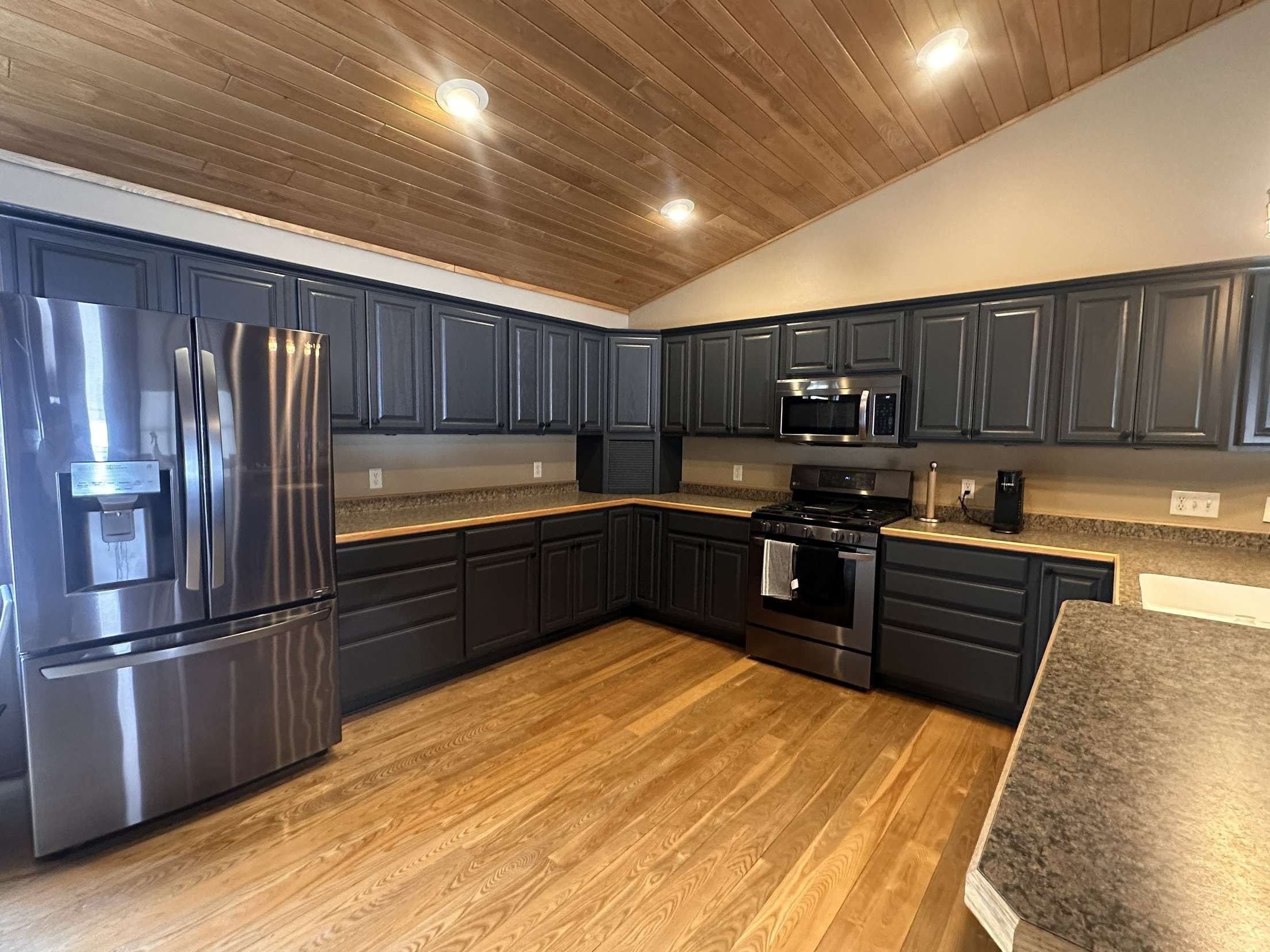 Professionally painted black kitchen cabinets with black knobs in Stone Lake Wisconsin