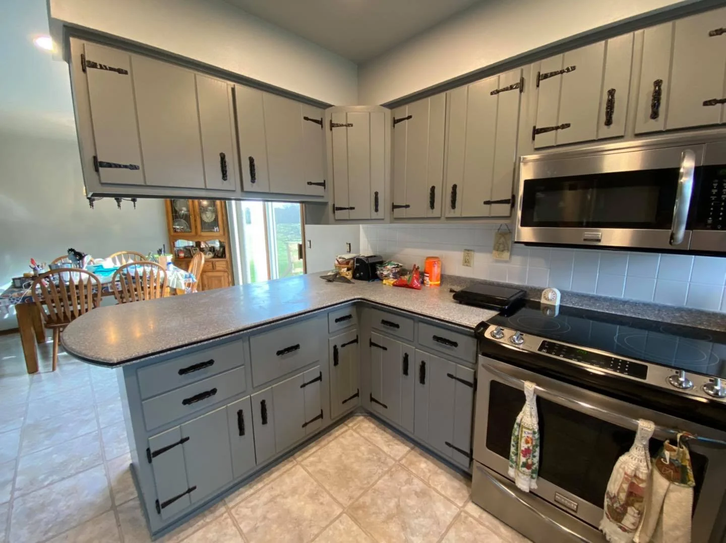 Gray farmhouse painted kitchen cabinets with vintage hardware refinished in black