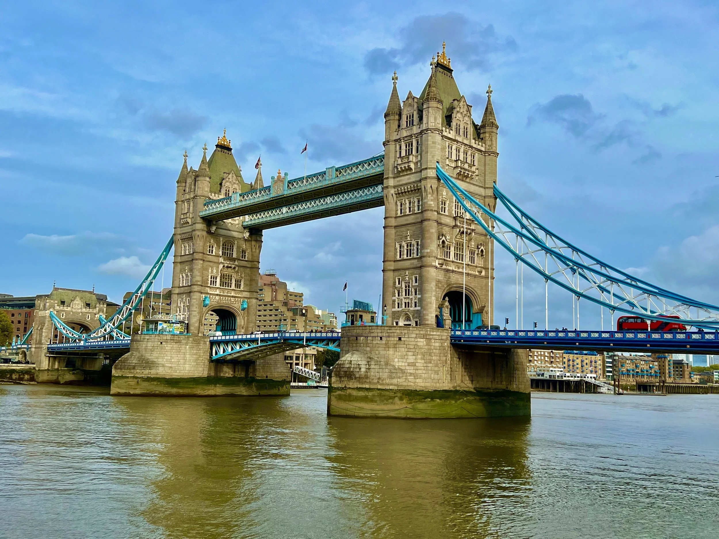 The Tower Bridge in London under a blue sky, spanning the River Thames.