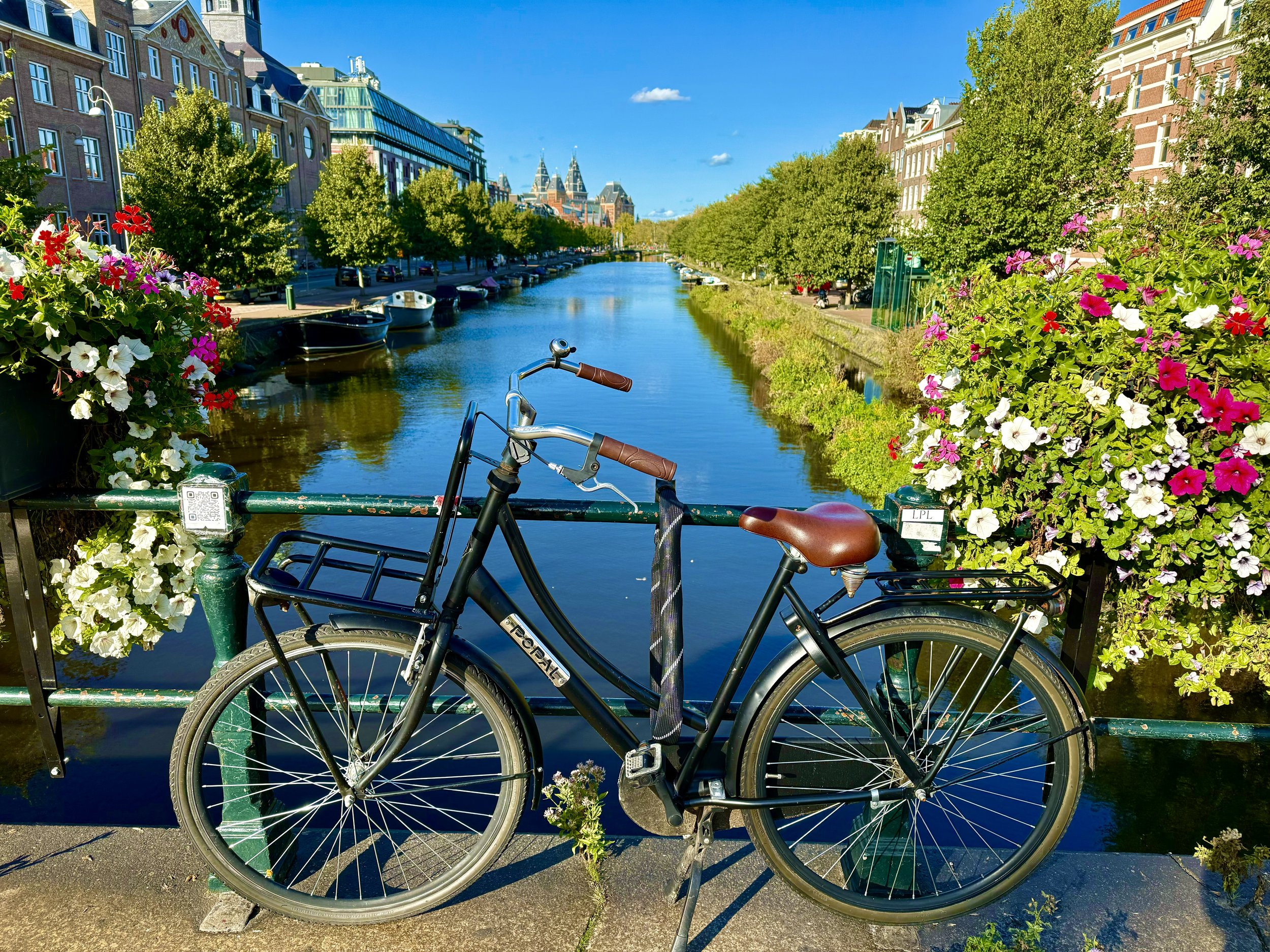 A bicycle parked on a bridge over a canal in Amsterdam.