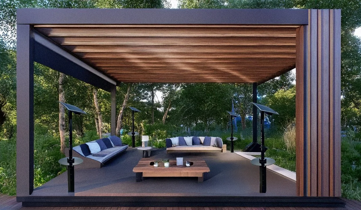 Outdoor seating area with two curved couches, a wooden coffee table, and around four tall patio heaters under a wooden pergola, surrounded by trees and greenery.