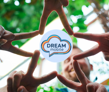 Four people forming a heart shape with their hands around a circular Dream Mobile logo