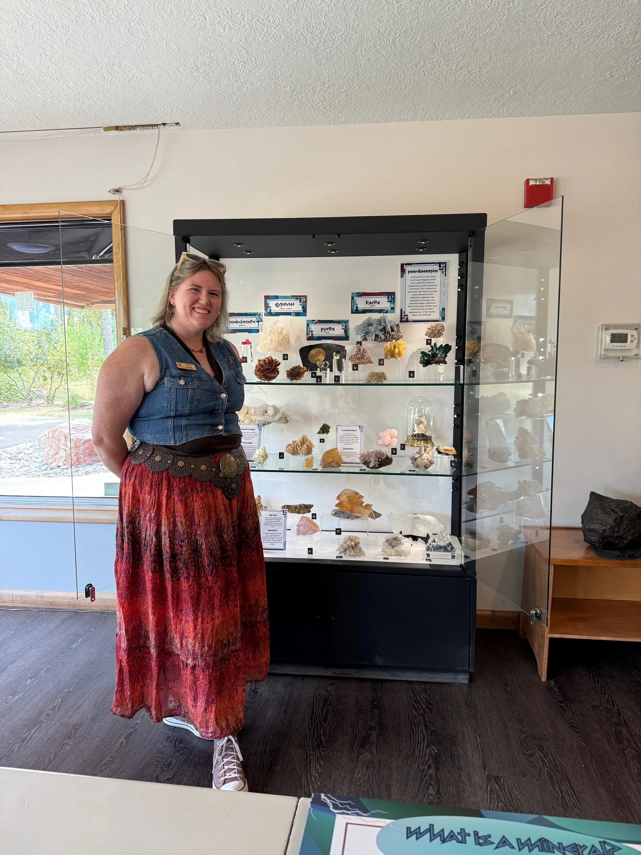 2025 Summer Intern in front of the display they designed