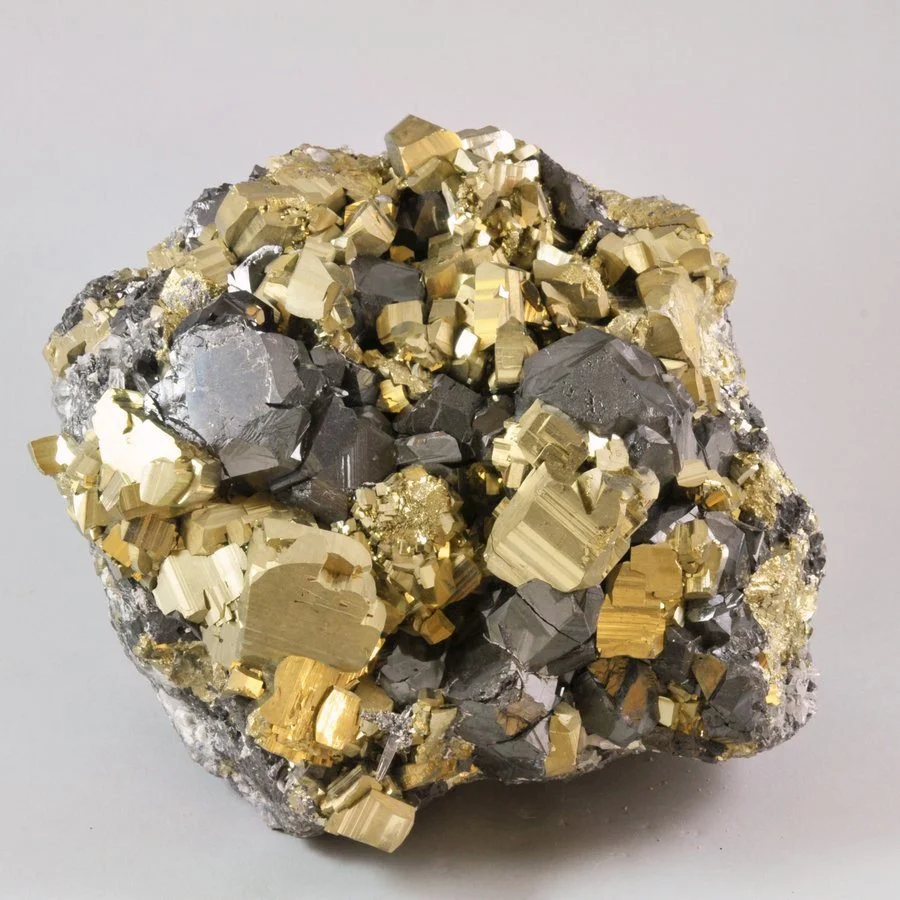 Pyrite specimen with interlocking cubic crystals showing a bright metallic gold color.