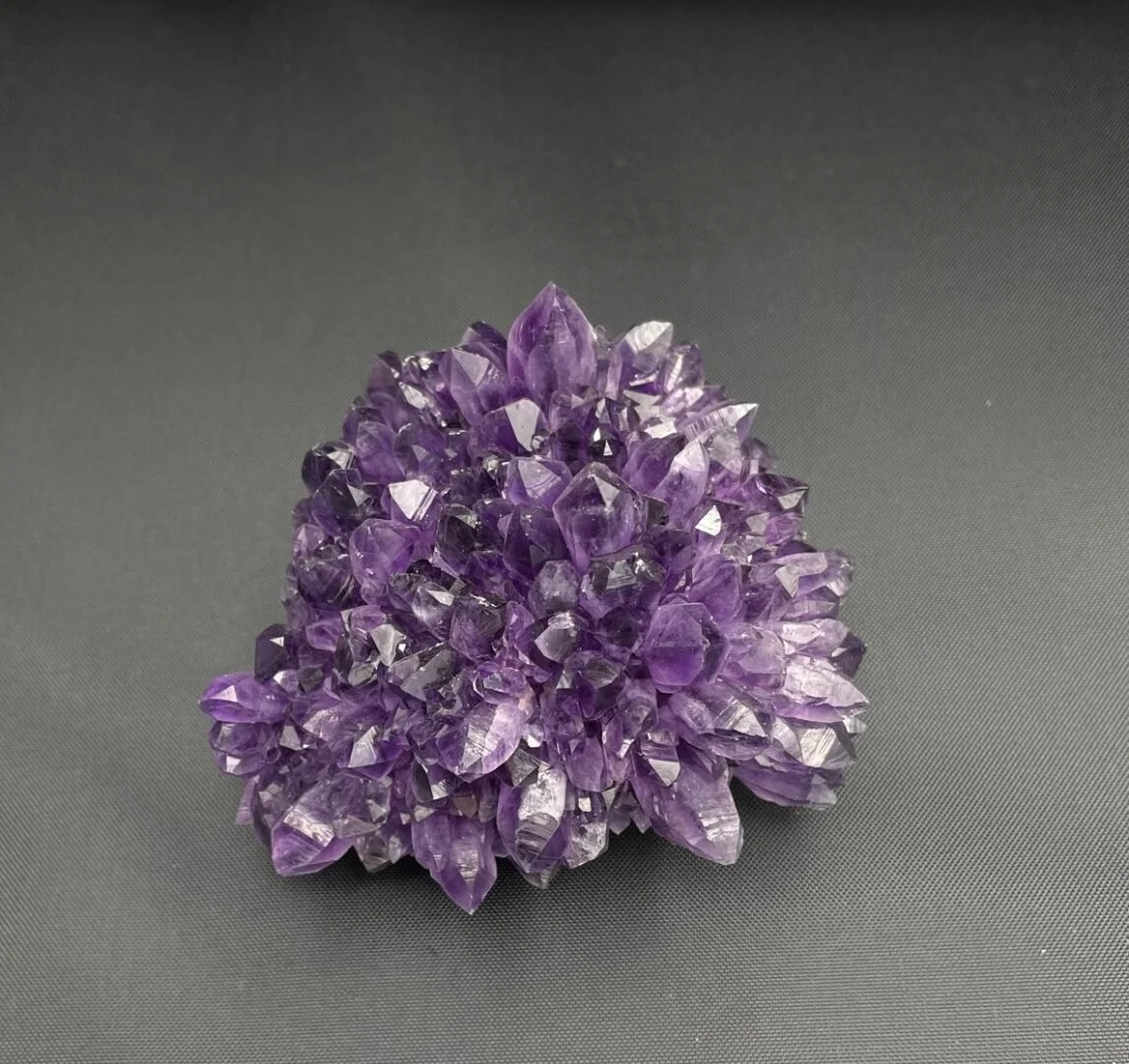 Amethyst cluster showing tightly grouped prismatic crystals with rich purple tones and pointed terminations.