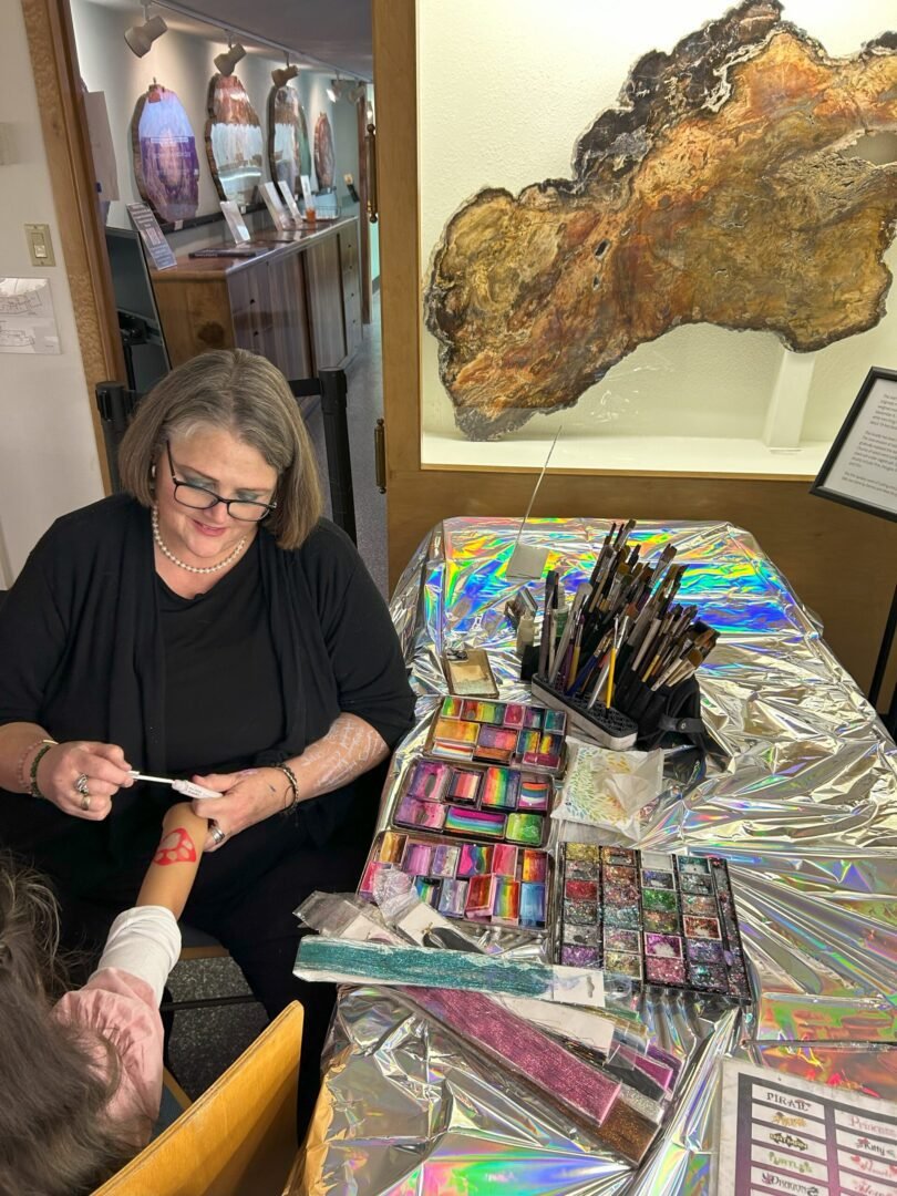 Woman applying temporary tattoo with glitter.