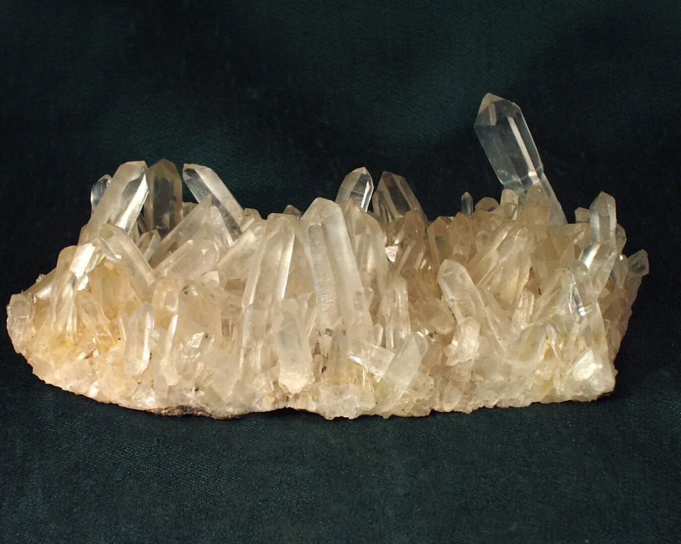 Quartz crystal cluster showing elongated, prismatic crystals with translucent to milky coloration and pointed tips.