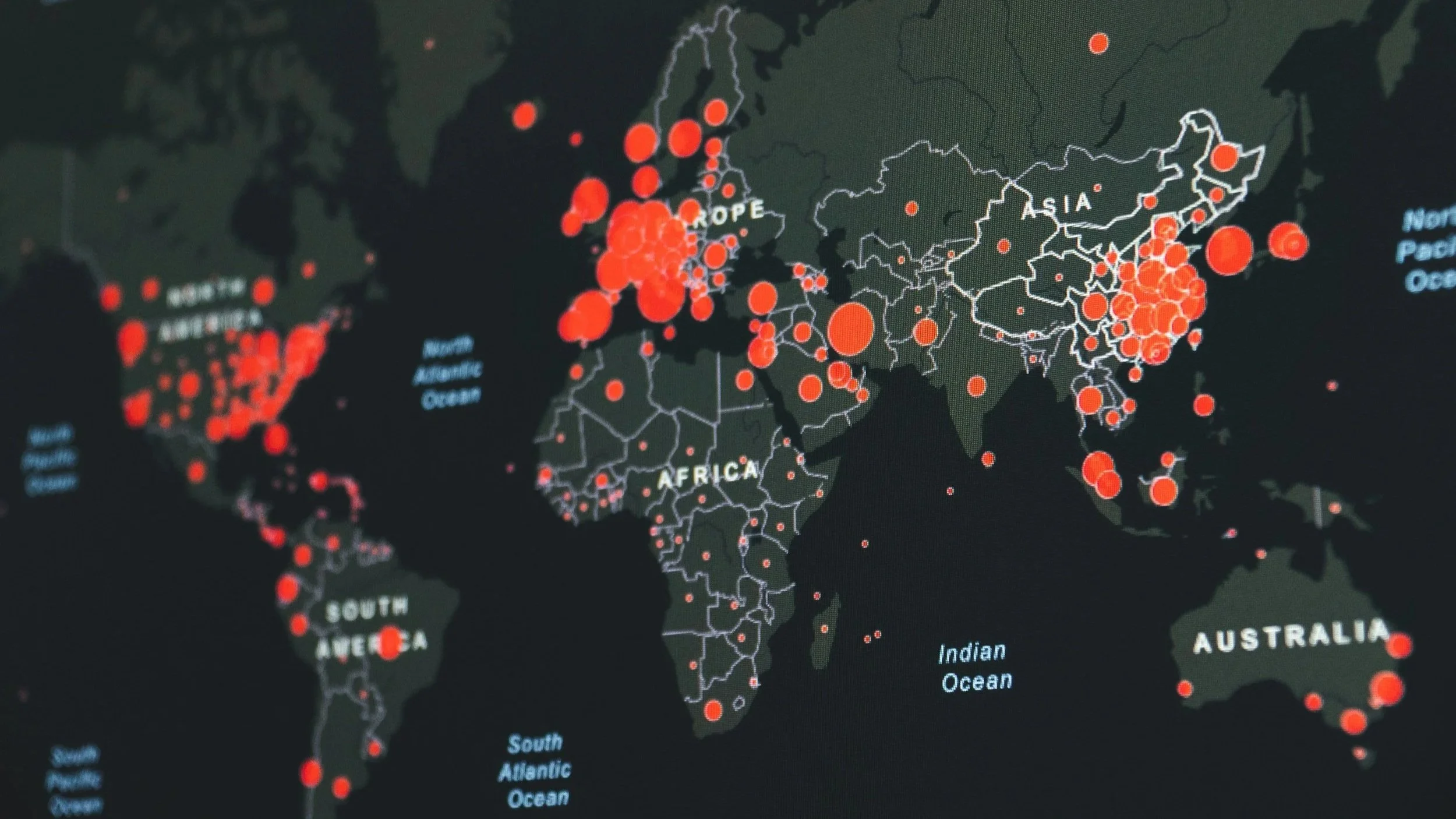A world map with countries outlined in white, showing a concentration of red circles across Europe, parts of Asia, and the eastern United States, representing data points or statistics.