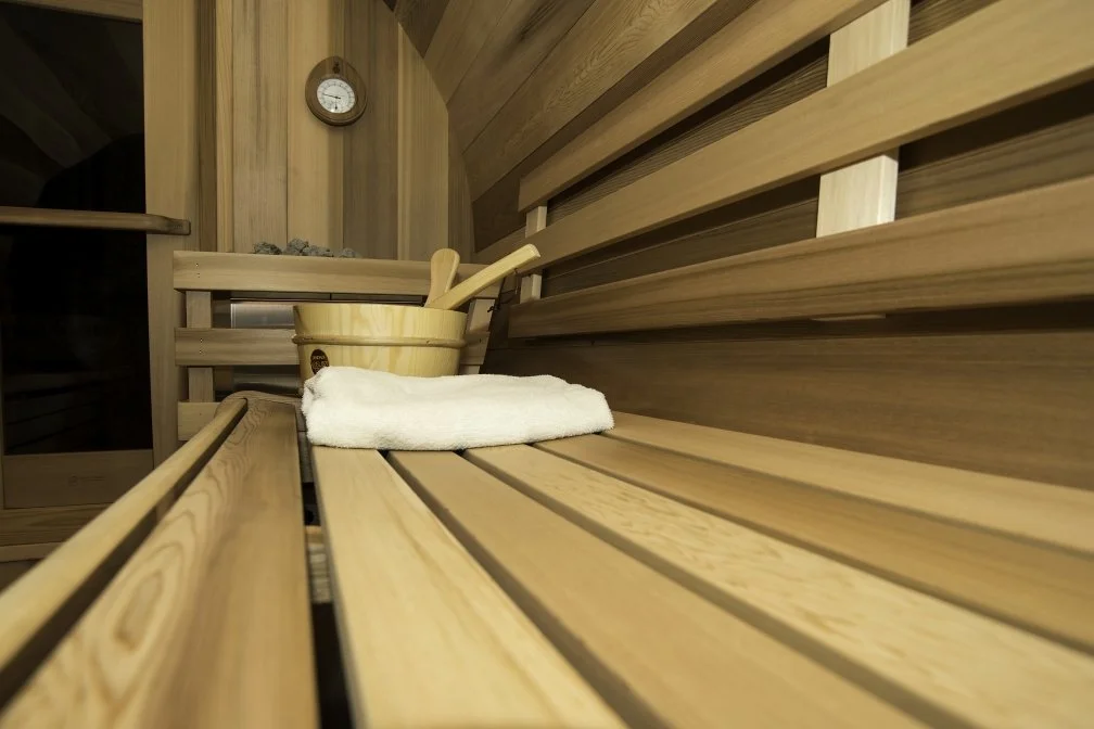 Inside red cedar sauna with water bucket for steam