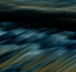 Blurry image of water or waves, difficult to discern specific details.