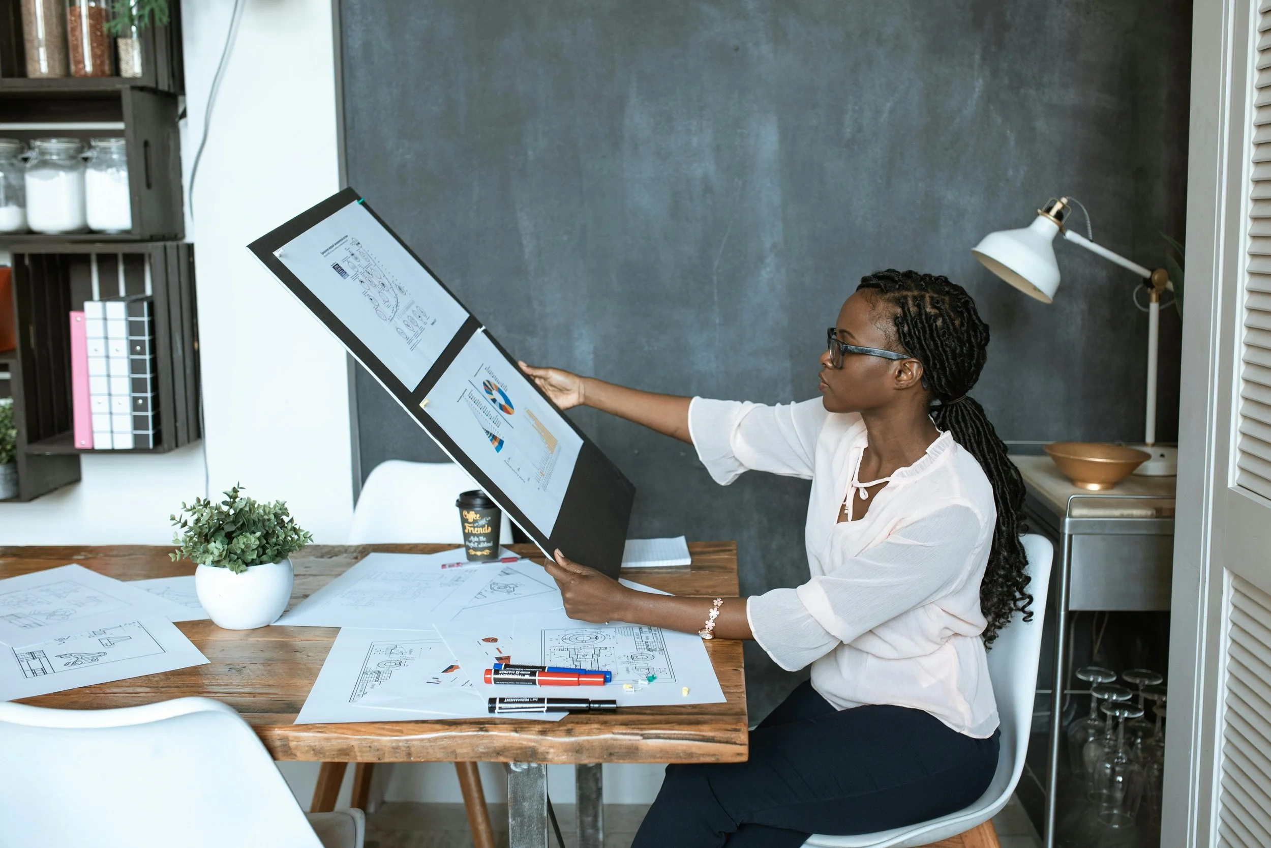 Woman sitting at desk looking over her work. Photo by RDND Stock project
