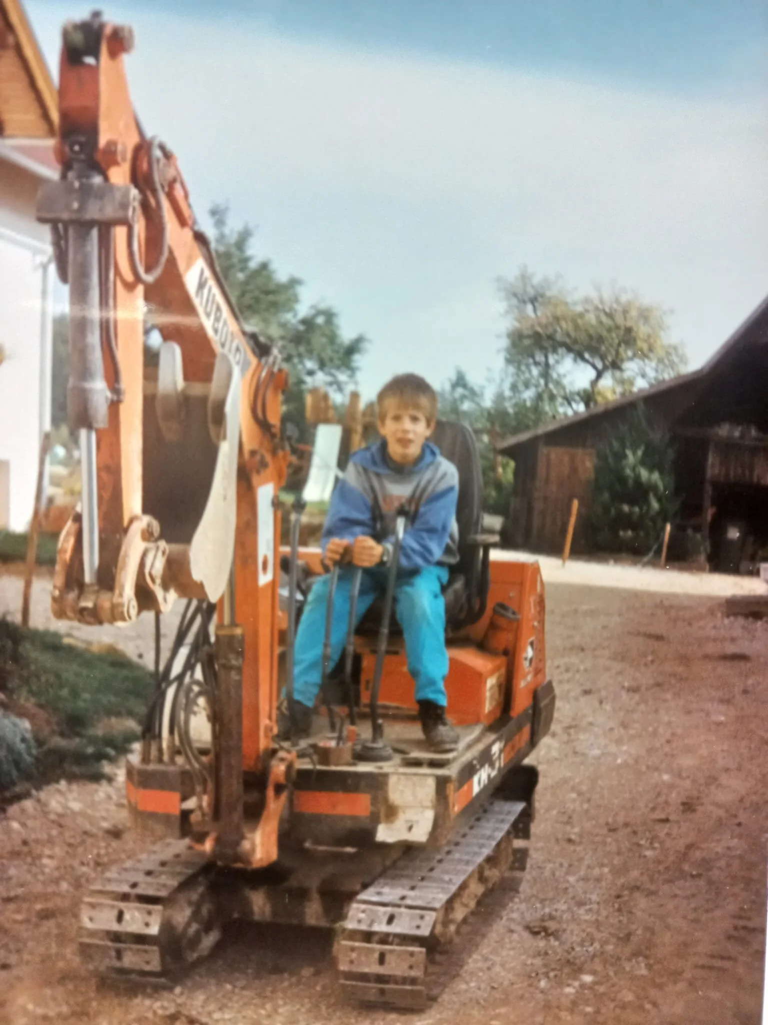 Ein Junge sitzt auf einem Bagger. Bagger Arbeiten als Kind
