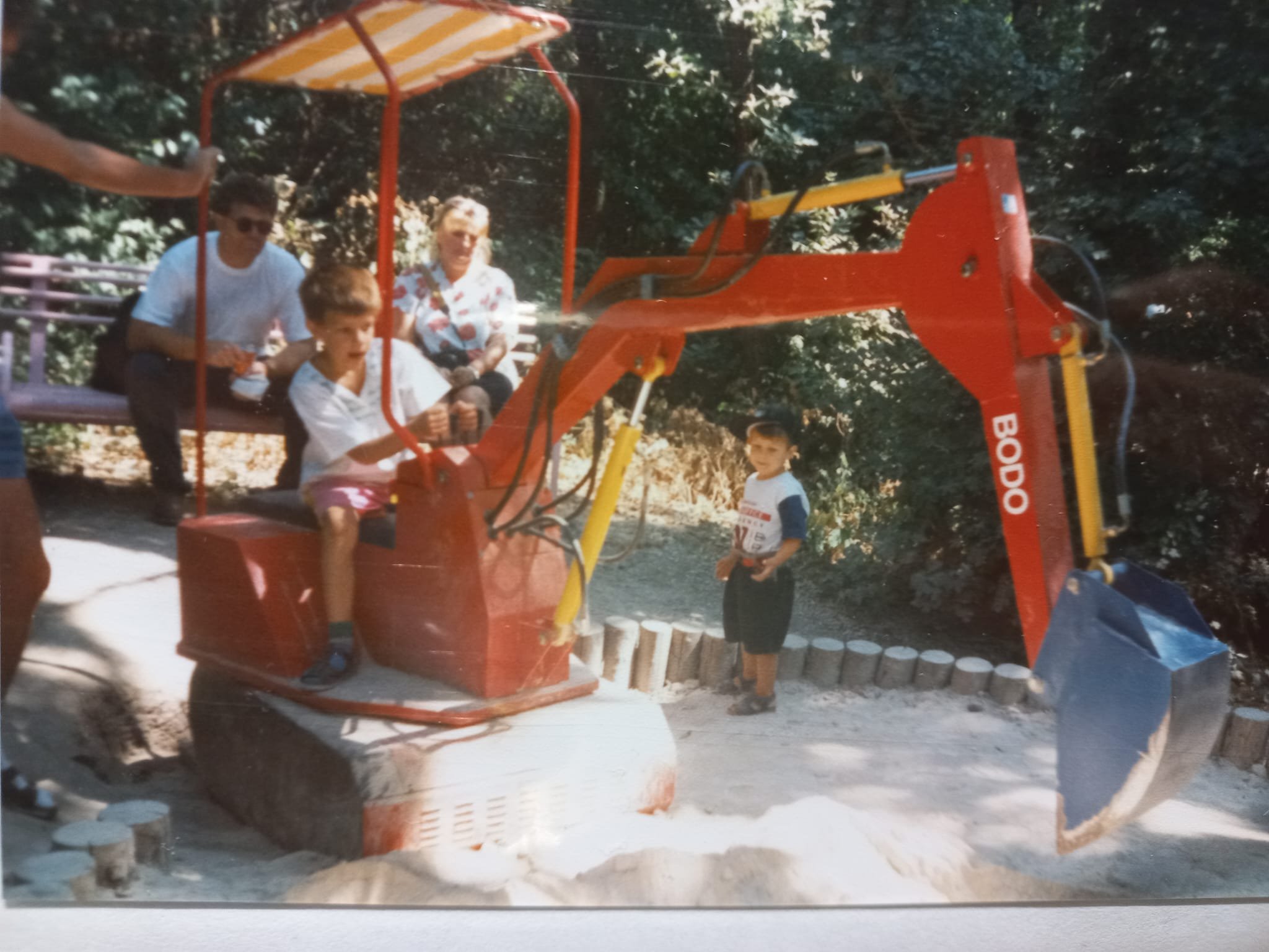 Kind spiet auf einer Sandkastenmaschine mit einem Bagger