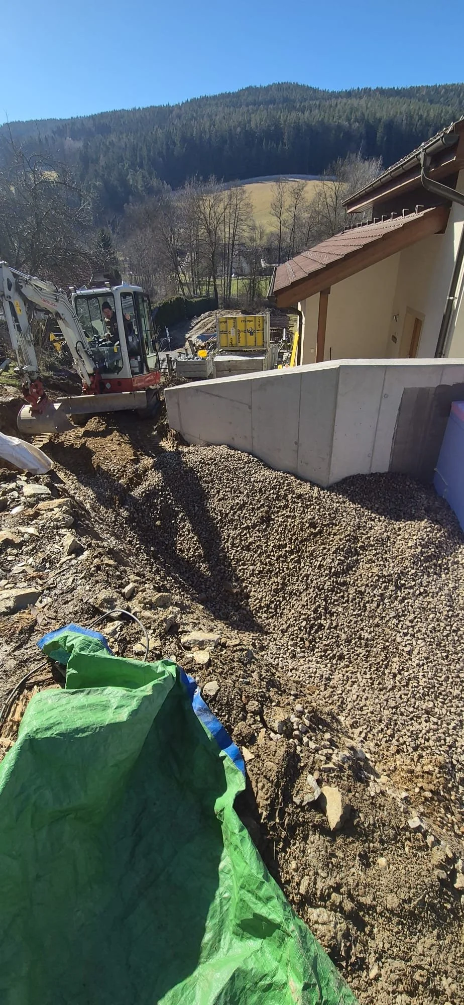 Baustelle mit Erdbewegungen, Bagger und Bauzubehör.
