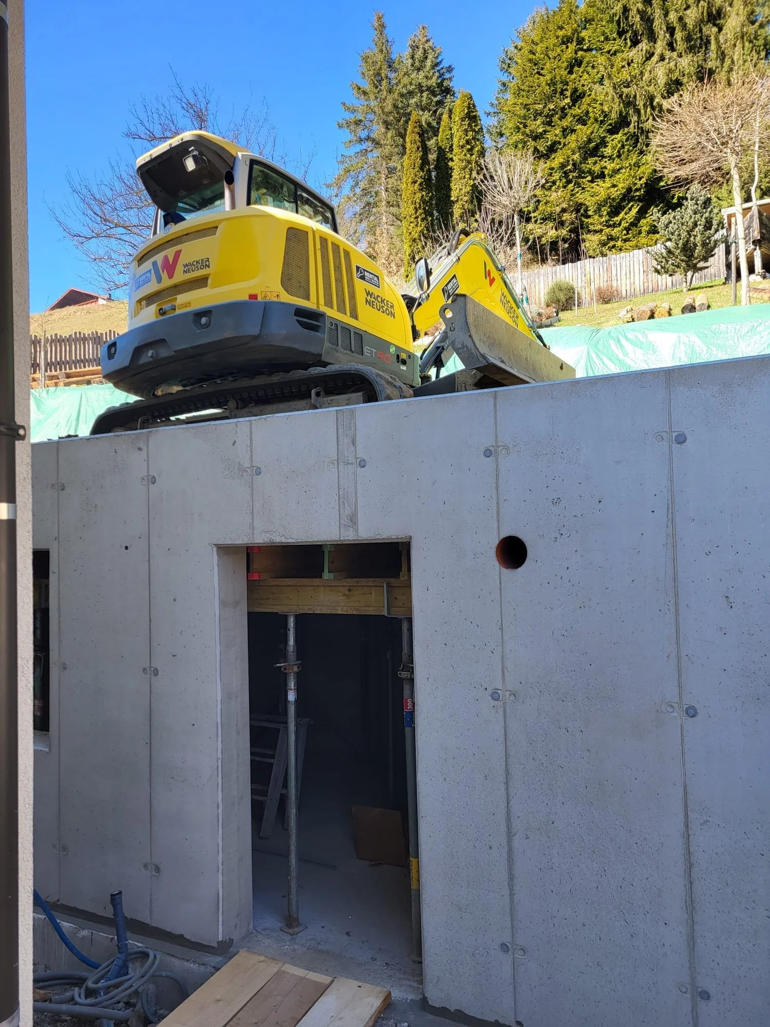 Bauarbeiten mit gelbem Bagger, der auf einer Baustelle steht.