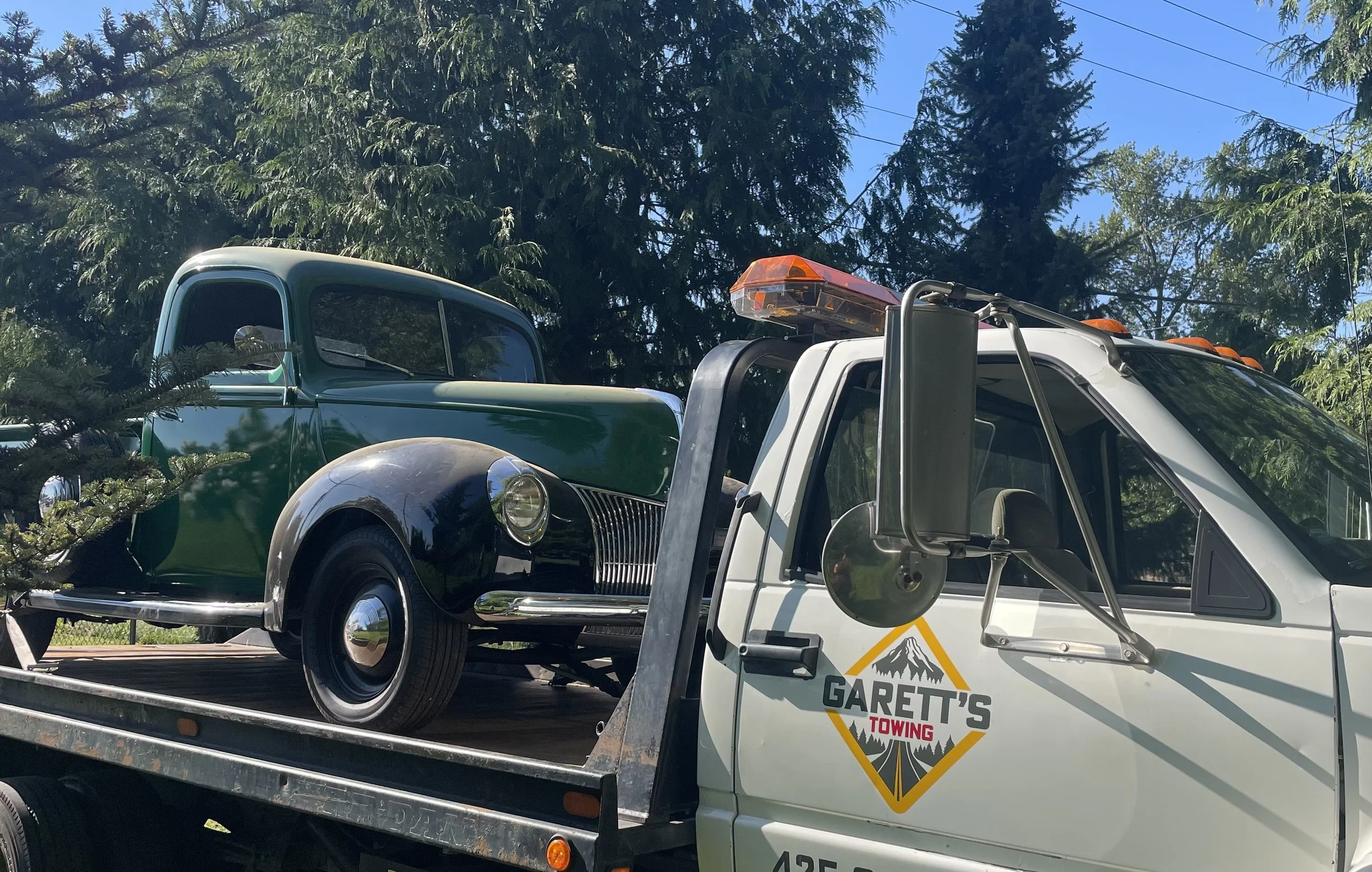 Classic truck on back of tow truck.