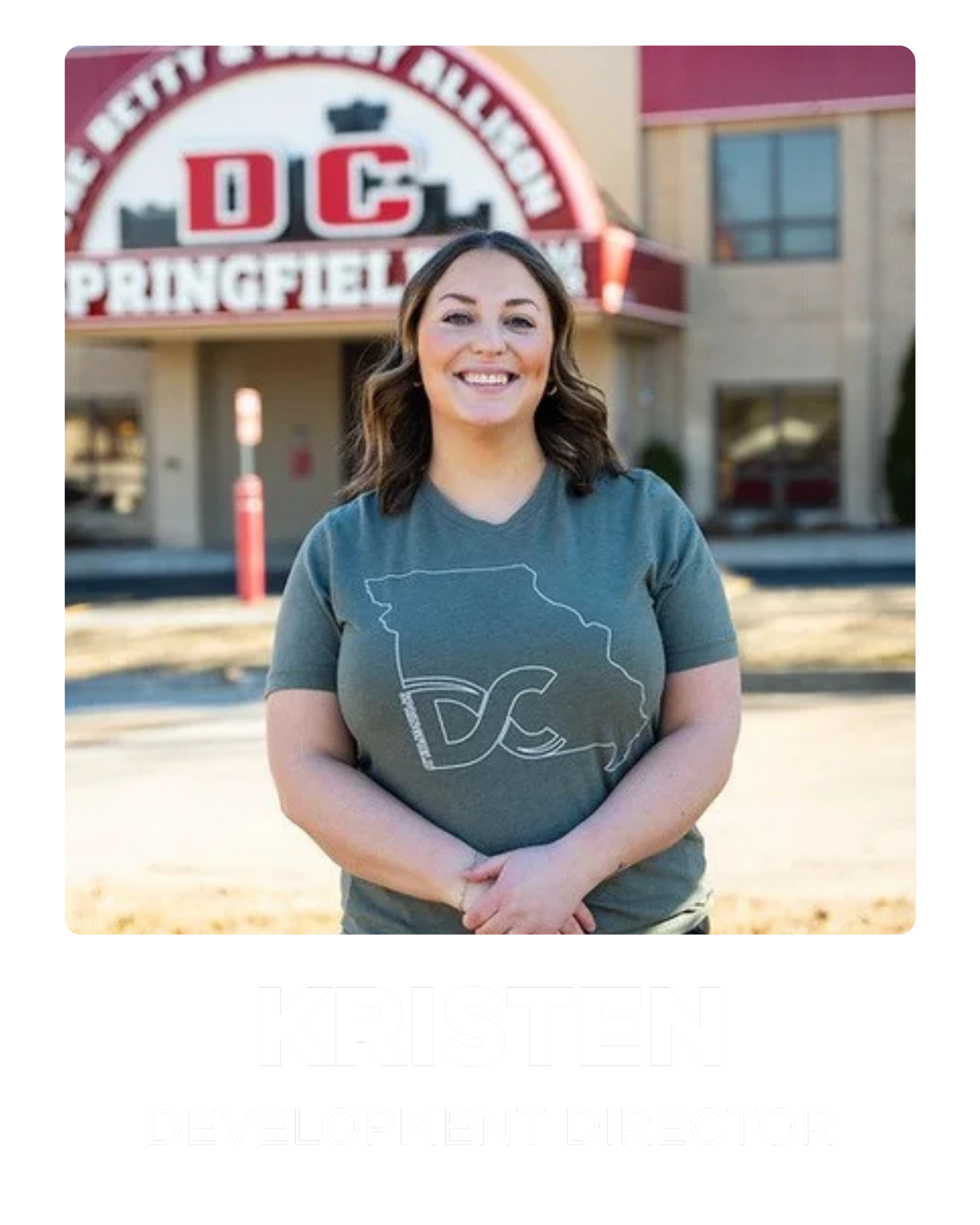 A woman standing in front of a building with a sign reading 'DC Springfield.' She is smiling and wearing a T-shirt with a map of Georgia and the letters 'DC.' The text below her reads 'Kristen, Development Director.'