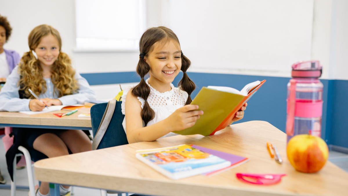 2 Girls at their desks reading for a blogpost about ela and social studies by Globally Taught