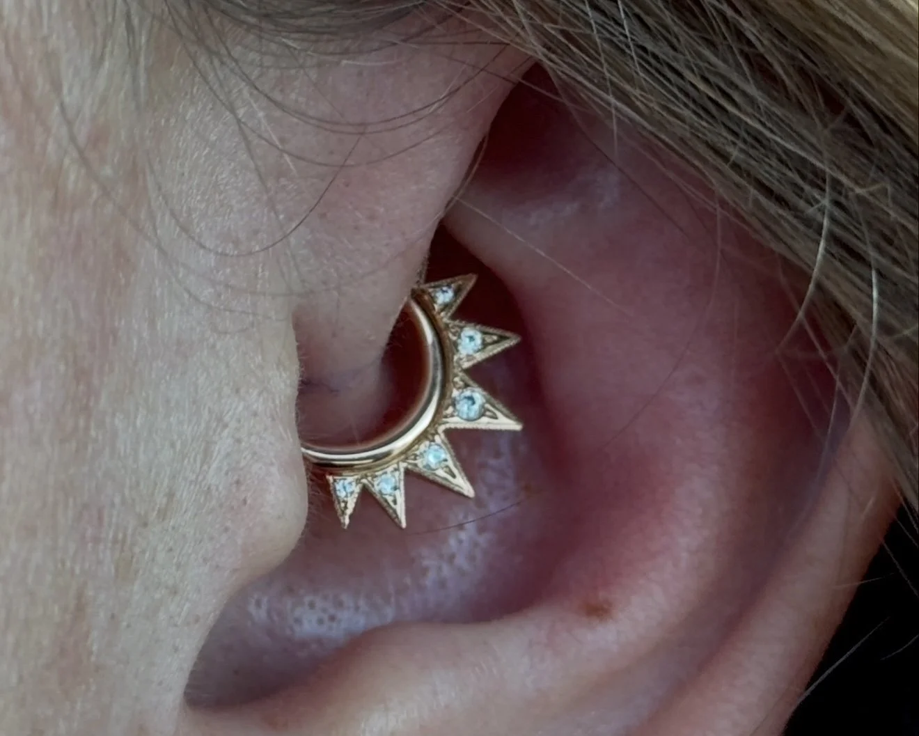 Daith piercing with a yellow gold Jupiter hinge ring made by Auris Jewelry