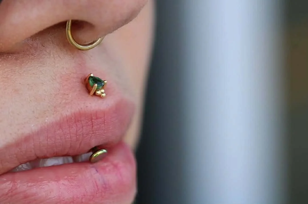 Vertical philitrum ( jestrum piercing) with a yellow gold Timka from BVLA Body Vision Los Angeles housing a genuine Emerald
Fine Body Jewelry