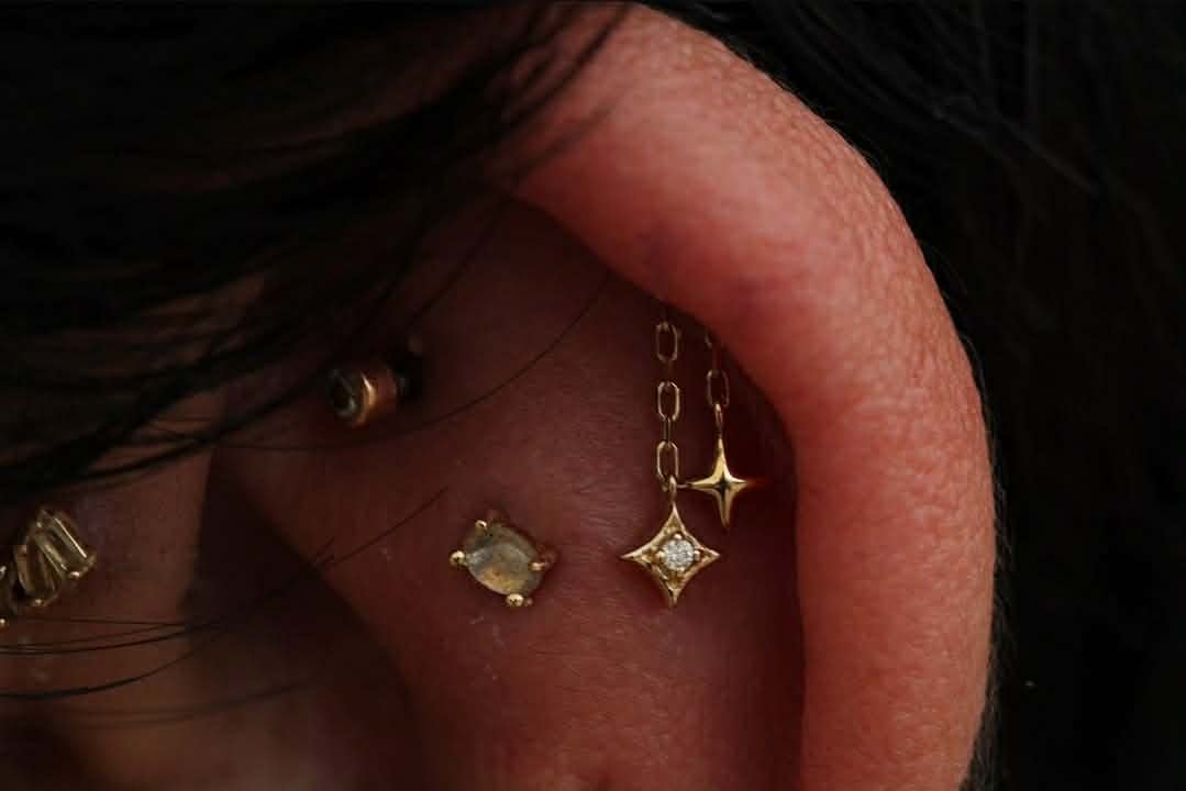 Hidden helix with a yellow gold Cozmo end featuring genuine white diamonds from Modern Mood Jewelry
Flat piercing with a genuine labradorite stone from Buddha Jewelry