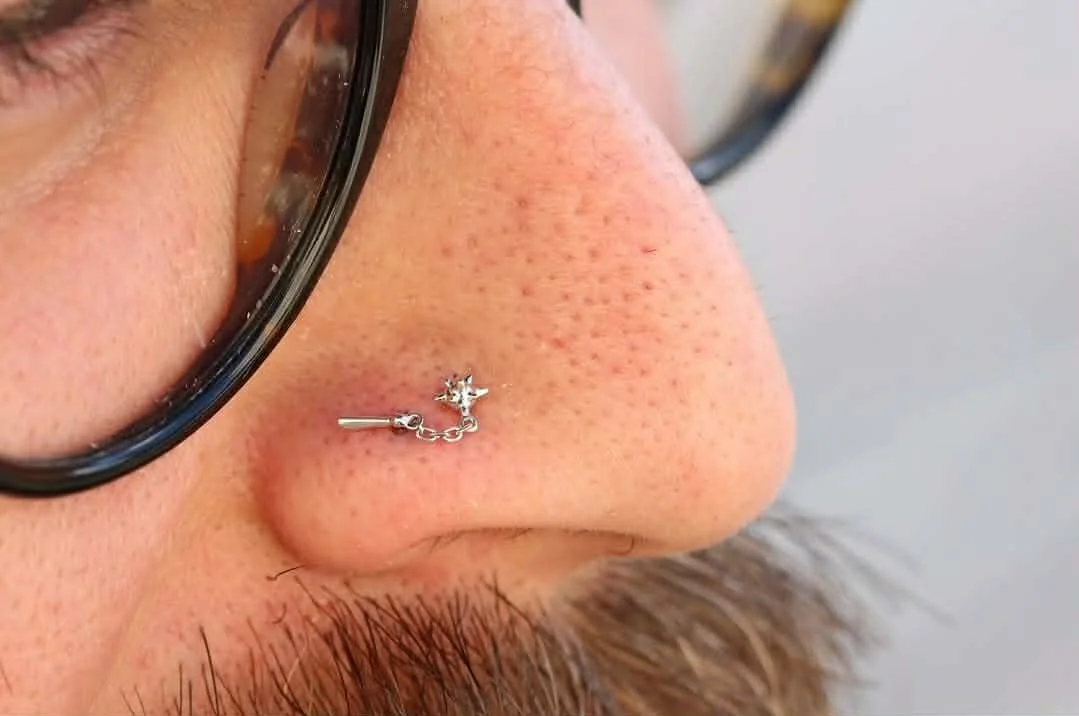 Double nostril piercing with a white gold flail end from Junipurr Jewelry