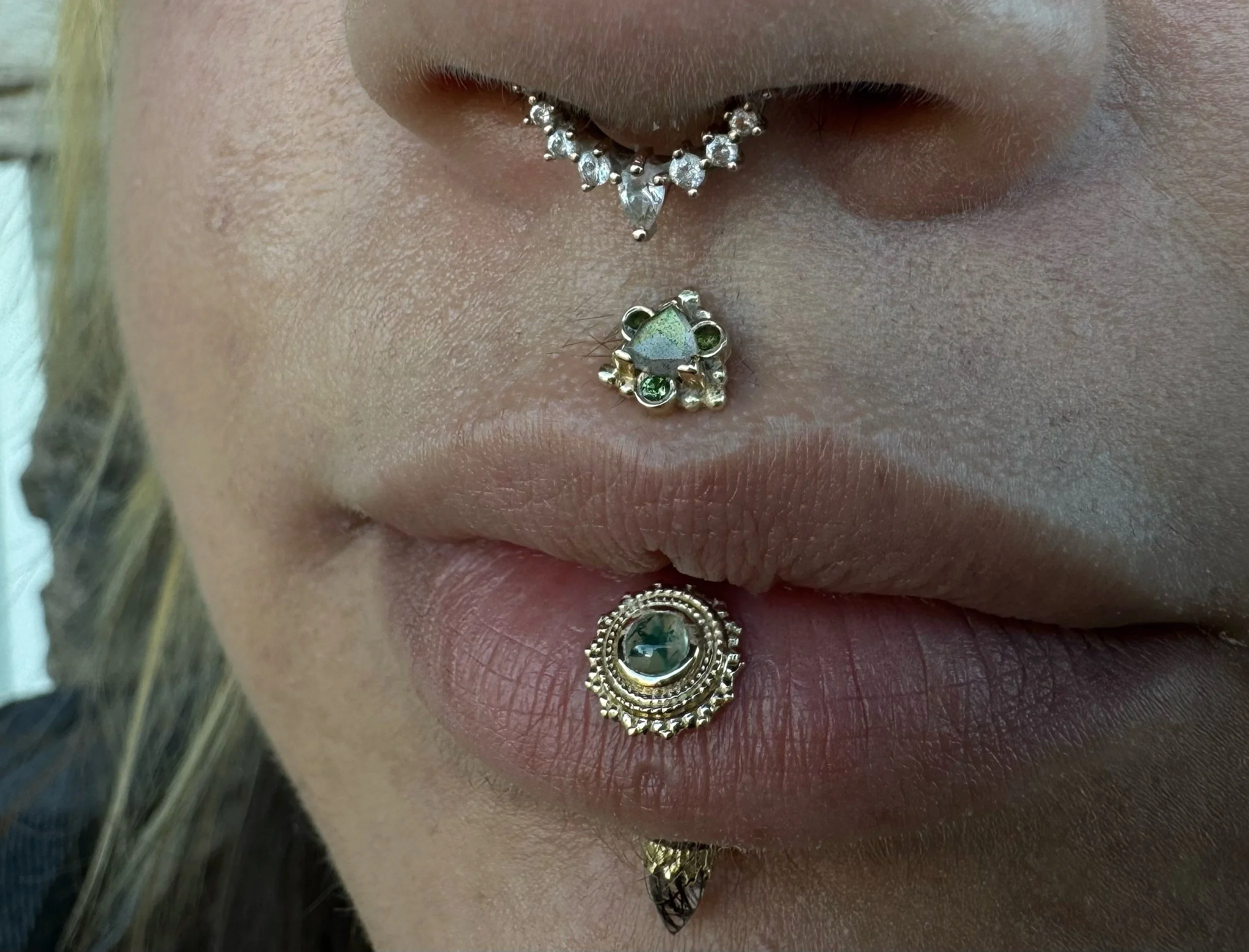 Facial piercing styling
Septum - rose gold and cz from Buddha Jewelry
Philtrum piercing - Helena BVLA yellow gold with rose cut labradorite and green tourmaline
Vertical Lip piercing - top: 8mm Afghan with moss agate bottom : King crown end