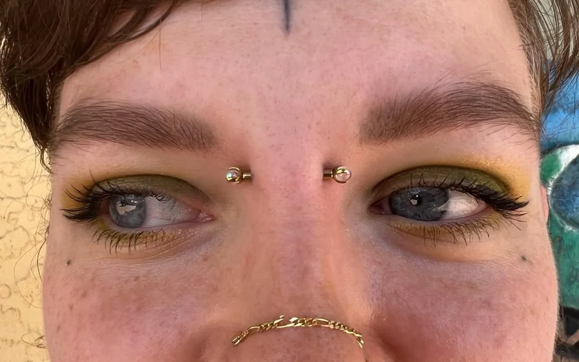 Bridge piercing with a implant grade titanium barbell anodized a yellow gold tone with 3mm clawset with aurora borealis glass ends