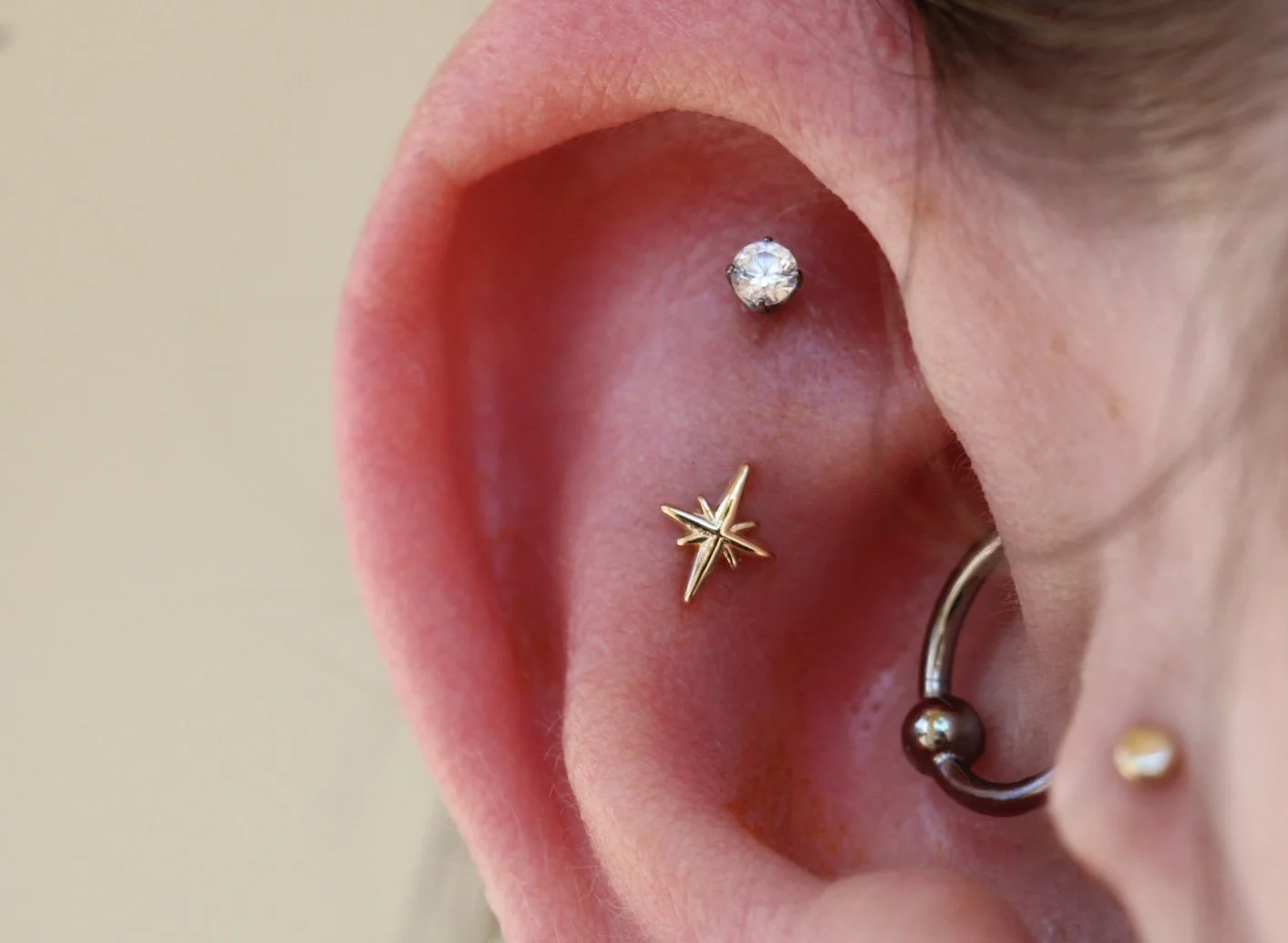 Flat piercing with a yellow gold Bangarang from Alchemy Adornment 
