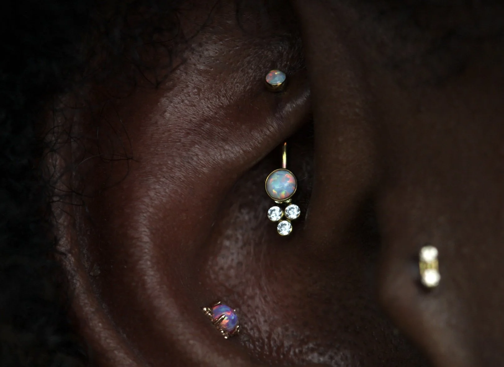 Rook piercing with implant grade titanium anodized in house with a white opal and white cz