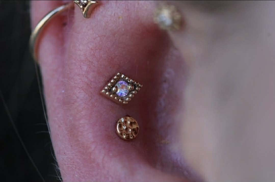 Double conch piercing with yellow gold 
Harlequin from BVLA Body Vision Los Angeles with Mercury Mist Topaz 
3mm Hammered disc from Norvoch