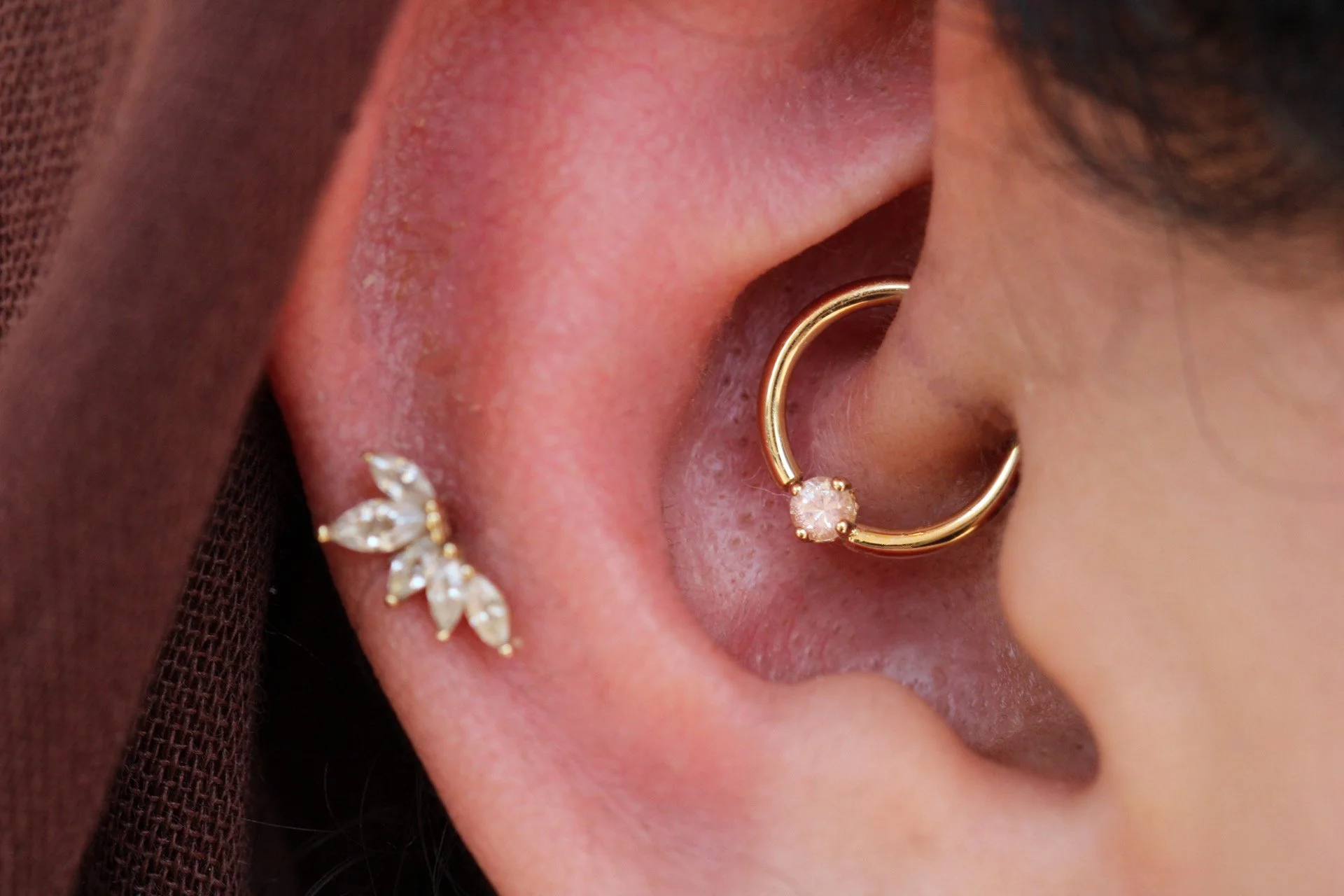 Daith piercing with a fixed gold seam ring from BVLA Body Vision Los Angeles in 14k yellow gold and Oregon Sunstone