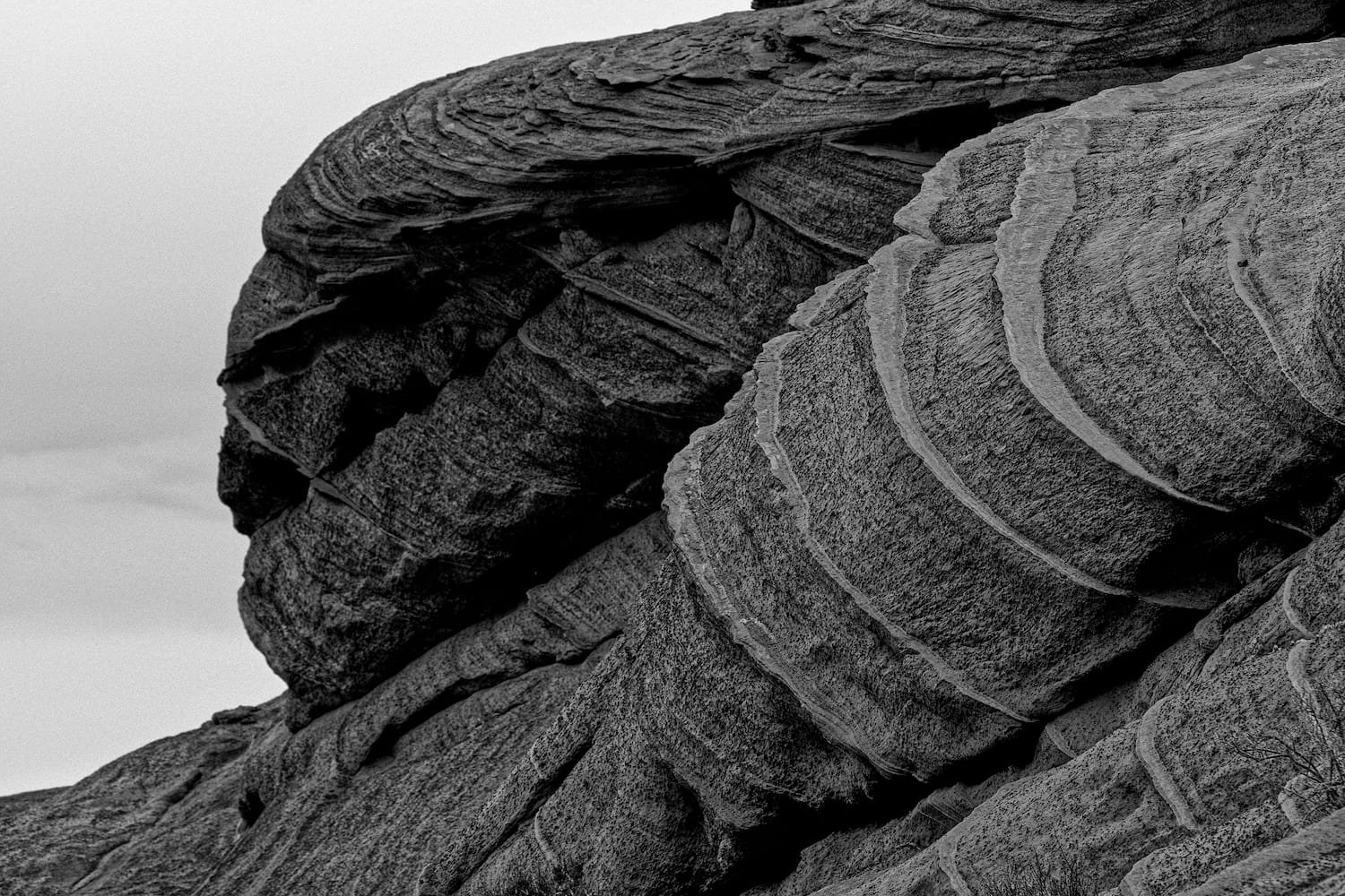 Close-up of layered, weathered rock formations with visible striations in black and white