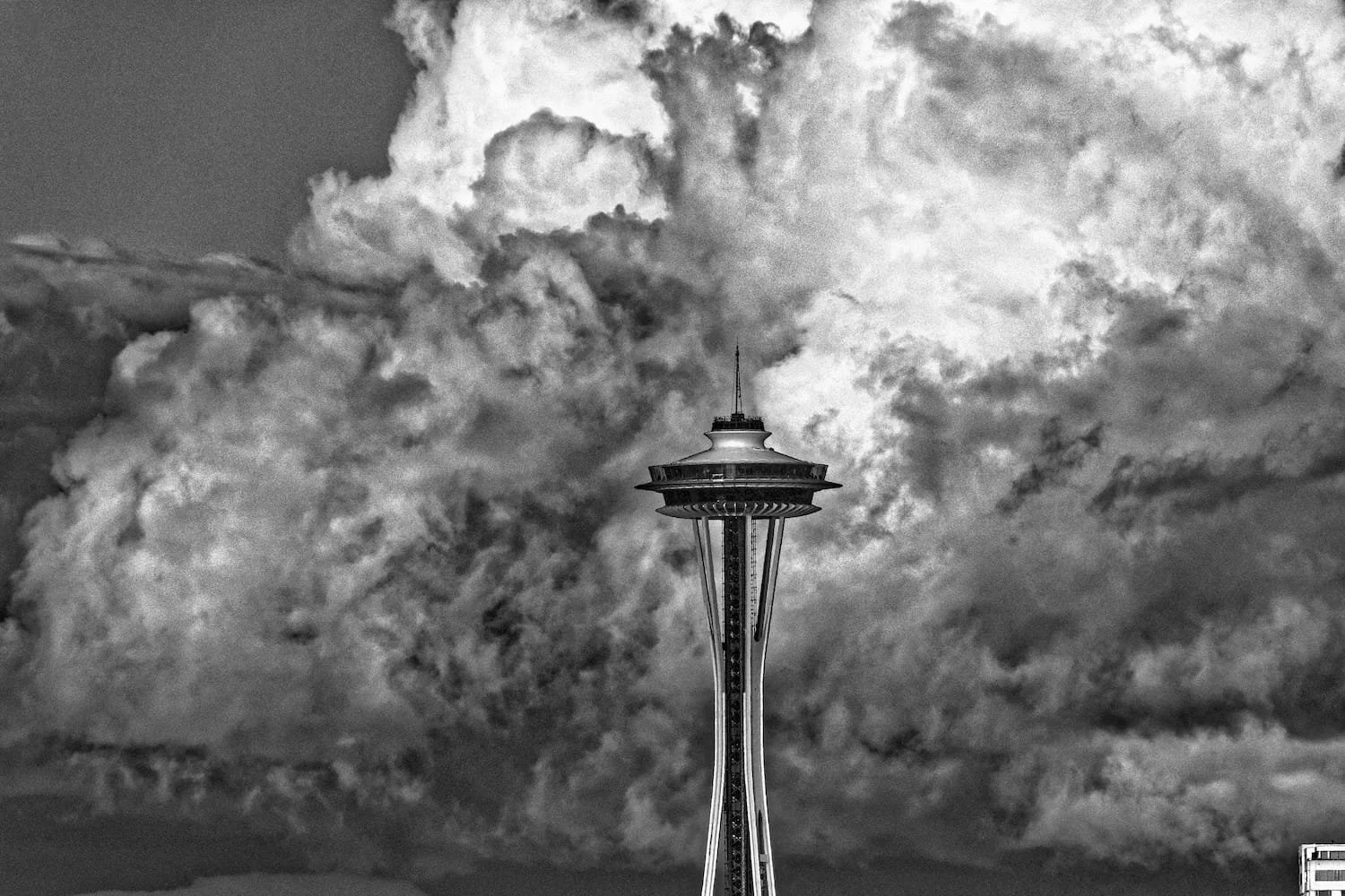 Black and white photo of the Space Needle against a cloudy sky.