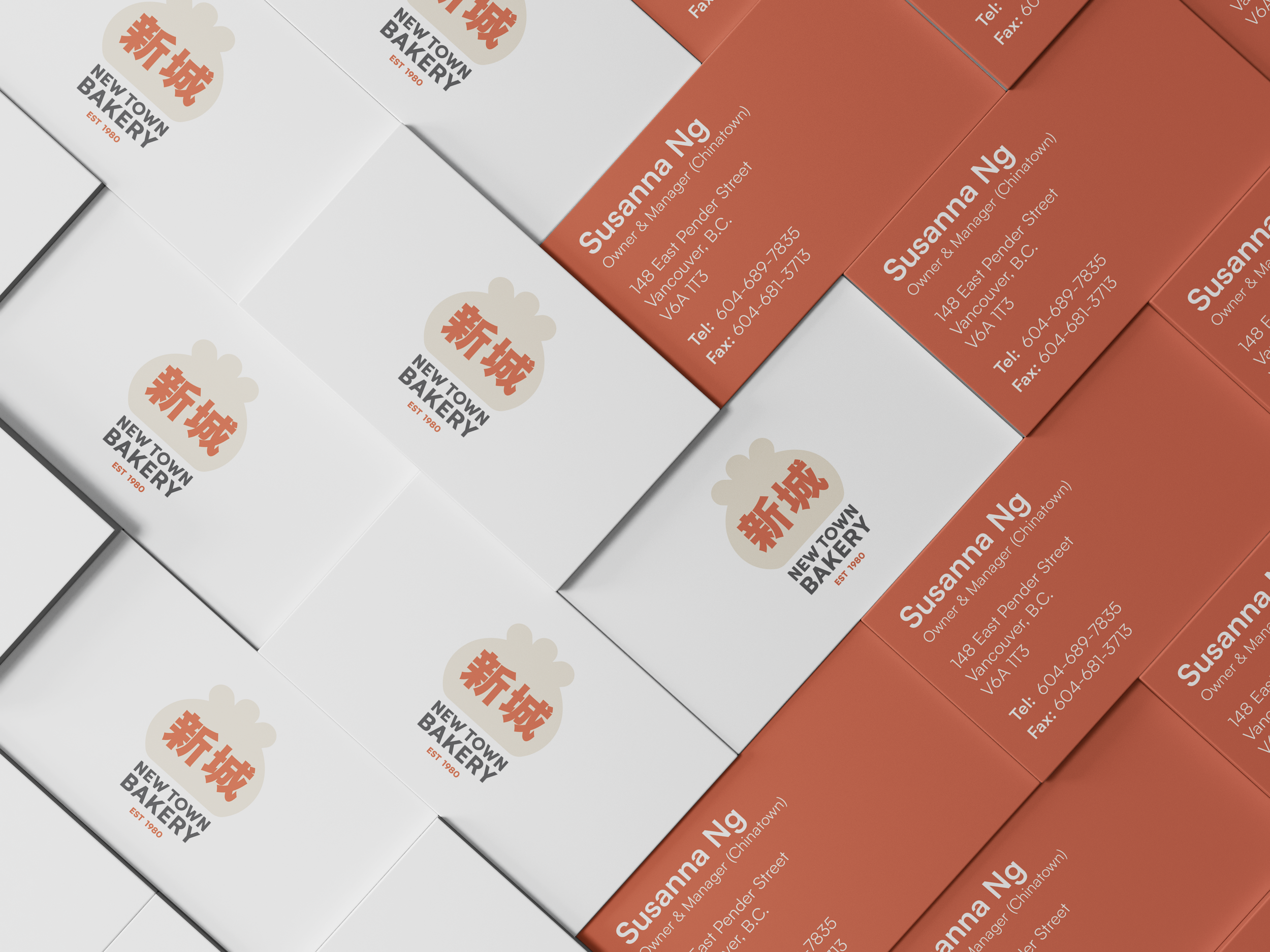 Stacked boxes with bakery branding, including logo with Chinese characters, and business card-style labels in white and orange with contact information for Susanna Ng, bakery owner in Vancouver, B.C.
