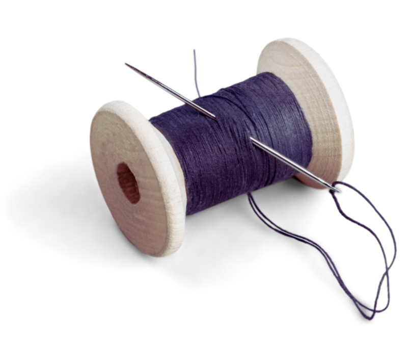A wooden spool of dark purple thread with a sewing needle inserted through the thread.